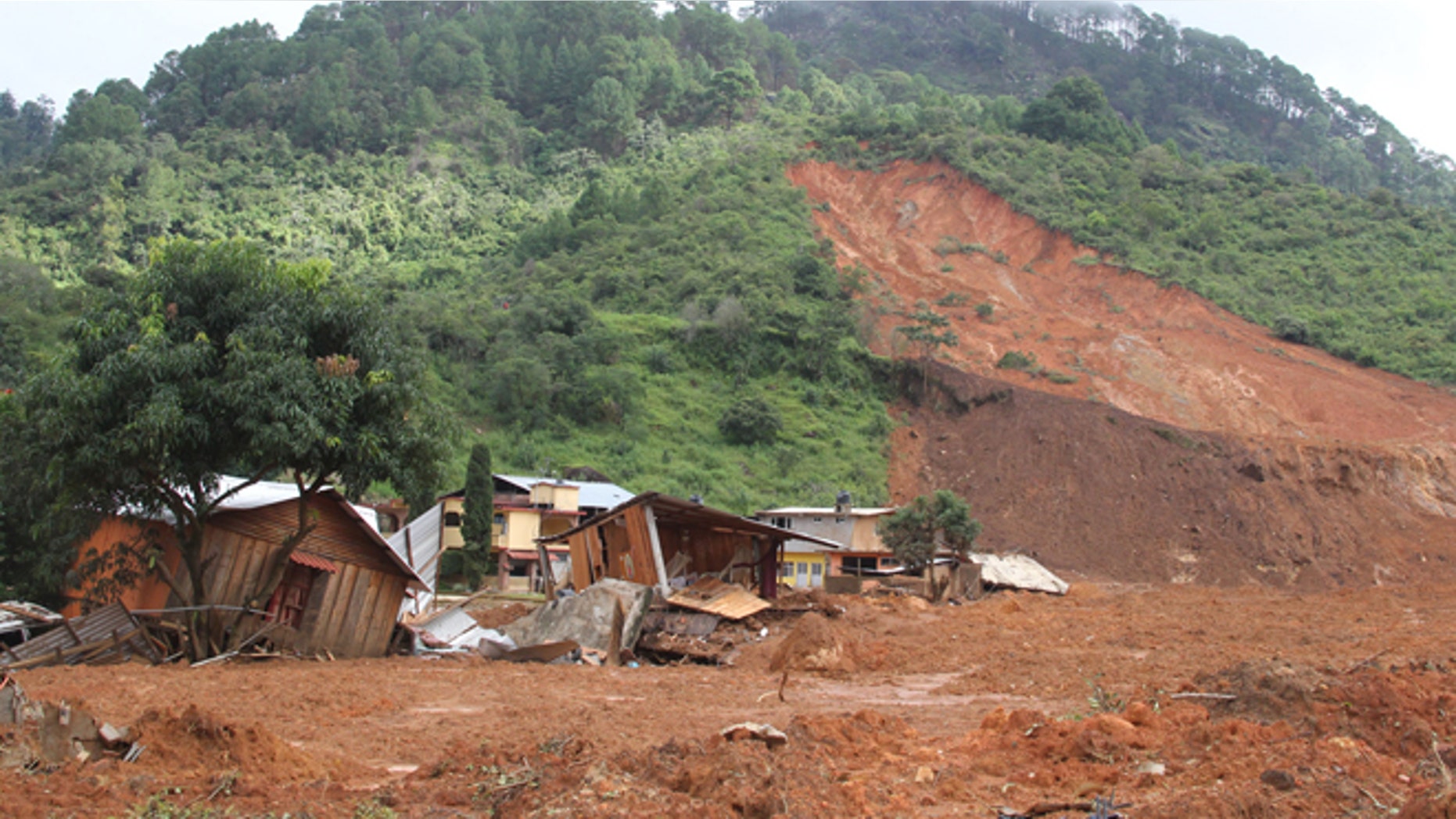 In this photo released by Mexico's Secretary of the Interior, structures lay in ruins at the site of a landslide in the village of La Pintada, Mexico, Thursday, Sept. 19, 2013. La Pintada was was affected by the twin paths of Tropical Storm Manuel and Hurricane Ingrid, which simultaneously pounded both of Mexico's coasts over the weekend, triggering floods and landslides across coastal and inland areas. (AP Photo/Mexico's Secretary of the Interior)