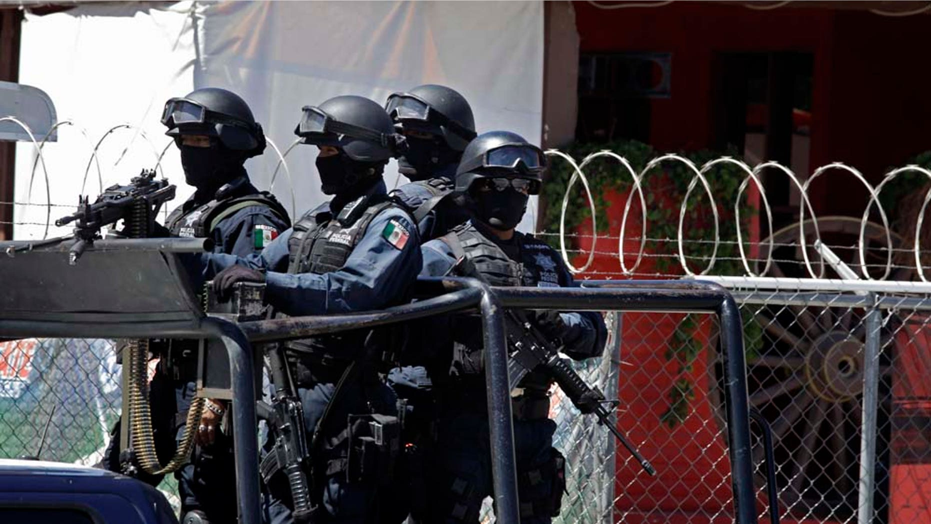In this picture taken Tuesday May 17, 2011, Mexican federal police stand outside the Goodbar Old West saloon, allegedly owned by Bernabe Monje Silva, in Durango, Mexico. Federal authorities claim that the March 27 arrest of Monje Silva, alias "M-14," led to the discovery of 219 bodies found in at least seven mass clandestine graves. (AP Photo/Dario Lopez-Mills)