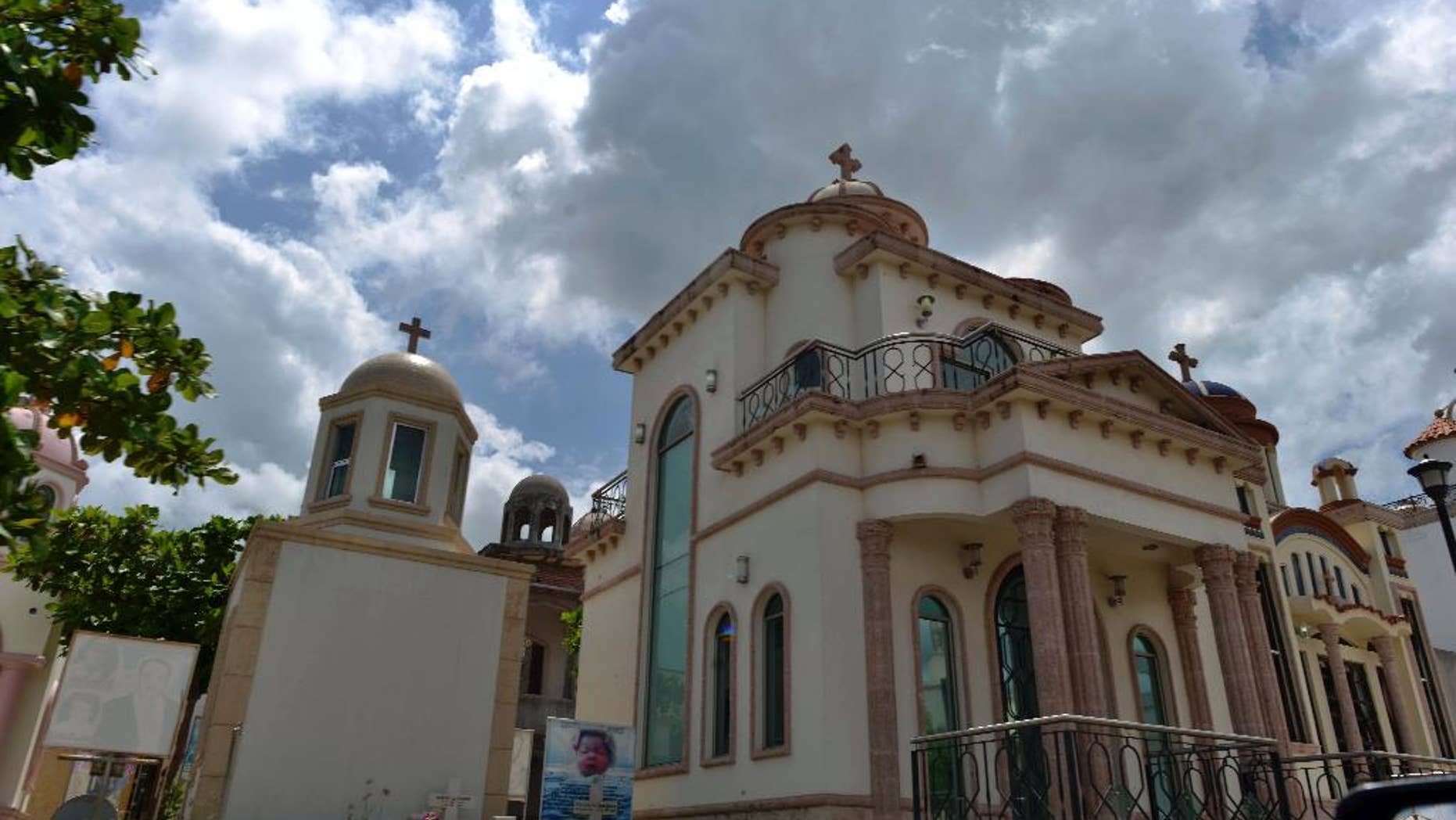 One of the many oversized luxury crypts stands inside the Jardines de Humaya cemetery, known for its palatial tombs built for deceased drug traffickers, in Culiacan, Mexico, Wednesday, July 22, 2015. Some of these crypts have air-conditioning, satellite TV and bathrooms. (AP Photo/Fernando Brito)