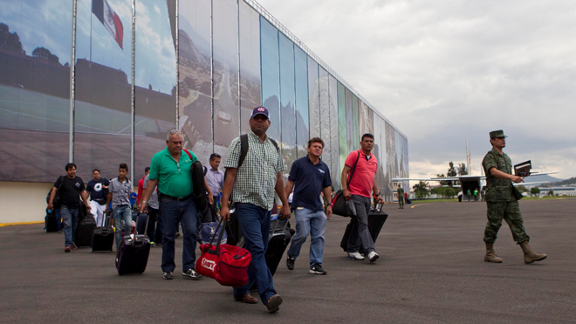 Mexican and foreign tourists arrive at an Air Force hangar in Mexico City after being airlifted out of the hurricane-ravaged resort area of Los Cabos by the Mexican armed forces, in Mexico City, Tuesday, Sept. 16, 2014. Travelers are being flown free of charge to airports in Tijuana, Mazatlan, Guadalajara and Mexico City to catch connecting flights and, in the case of foreigners, receive consular assistance. (AP Photo/Christian Palma)