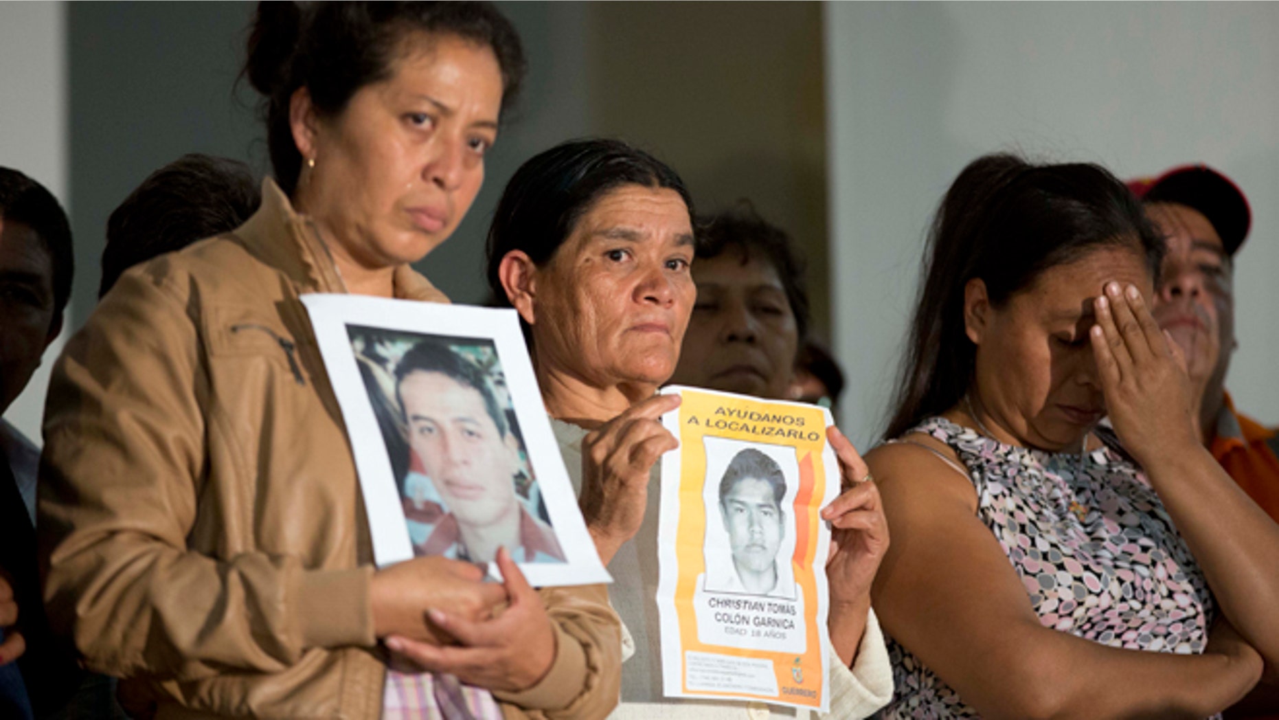Parents of missing students holding pictures of the missing, attend the press conference after a meeting with Mexico's President Enrique Pena Nieto in Mexico, City, Wednesday Oct. 29, 2014. President Enrique Pena Nieto met with parents of 43 teachers college students Wednesday for the first time since they disappeared over a month ago, when investigators say police detained the students and handed them over to a drug gang. (AP Photo/Eduardo Verdugo)