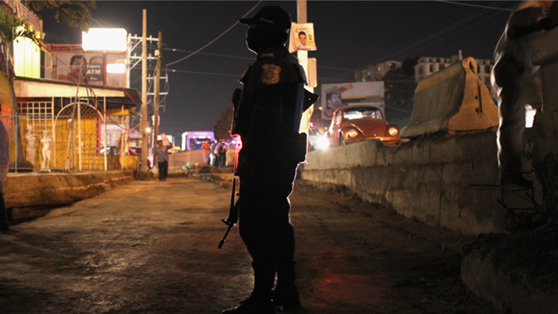 A federal policeman stands guard at the scene of a suspected drug-related execution on March 1, 2012 in Acapulco, Mexico. (Photo by John Moore/Getty Images)