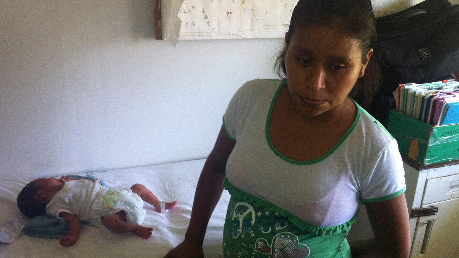 In this photo, 29-year-old Irma Lopez stands next to her newborn son Salvador at a clinic in the town of Jalapa de Diaz, Mexico. Mexico officials have suspended a health center director after Lopez, an indigenous woman, was denied entry to his clinic and was forced to give birth on the lawn.