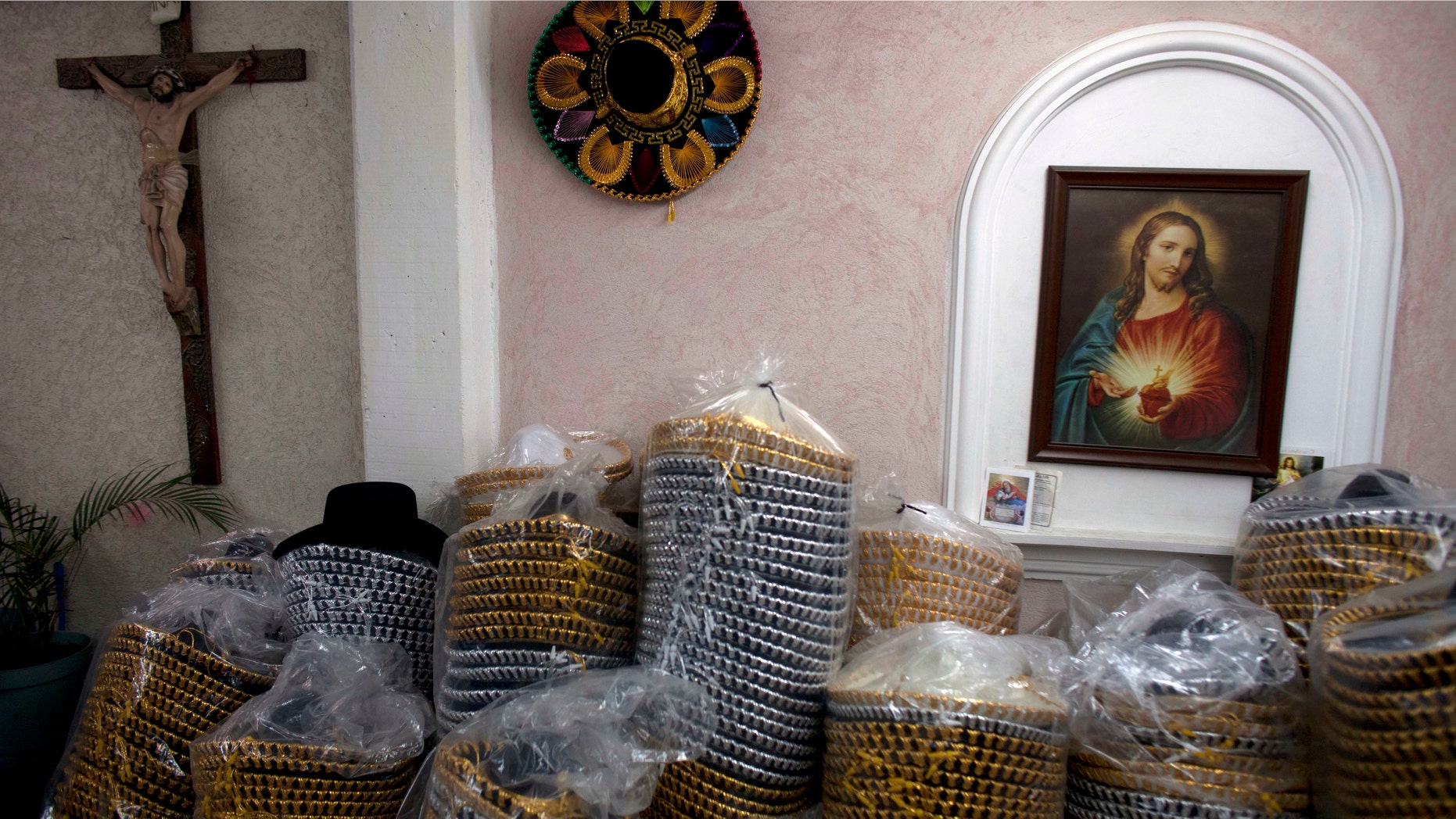 In this Feb. 29, 2012 photo, packaged Mexican sombreros stand next to religious images at the sombrero shop of Maria de la Luz Yepez, not shown, who is preparing three Mexican style sombreros to give as presents to Pope Benedict XVI, in the town of San Francisco del Rincon, near León, Mexico. The visit of Pope Benedict XVI, his first to Spanish-speaking Latin America, begins on March 23 in Mexico's central state of Guanajuato, where he will spend three days and give an outdoor Mass before heading to Cuba on March 26. (AP Photo/Dario Lopez-Mills)