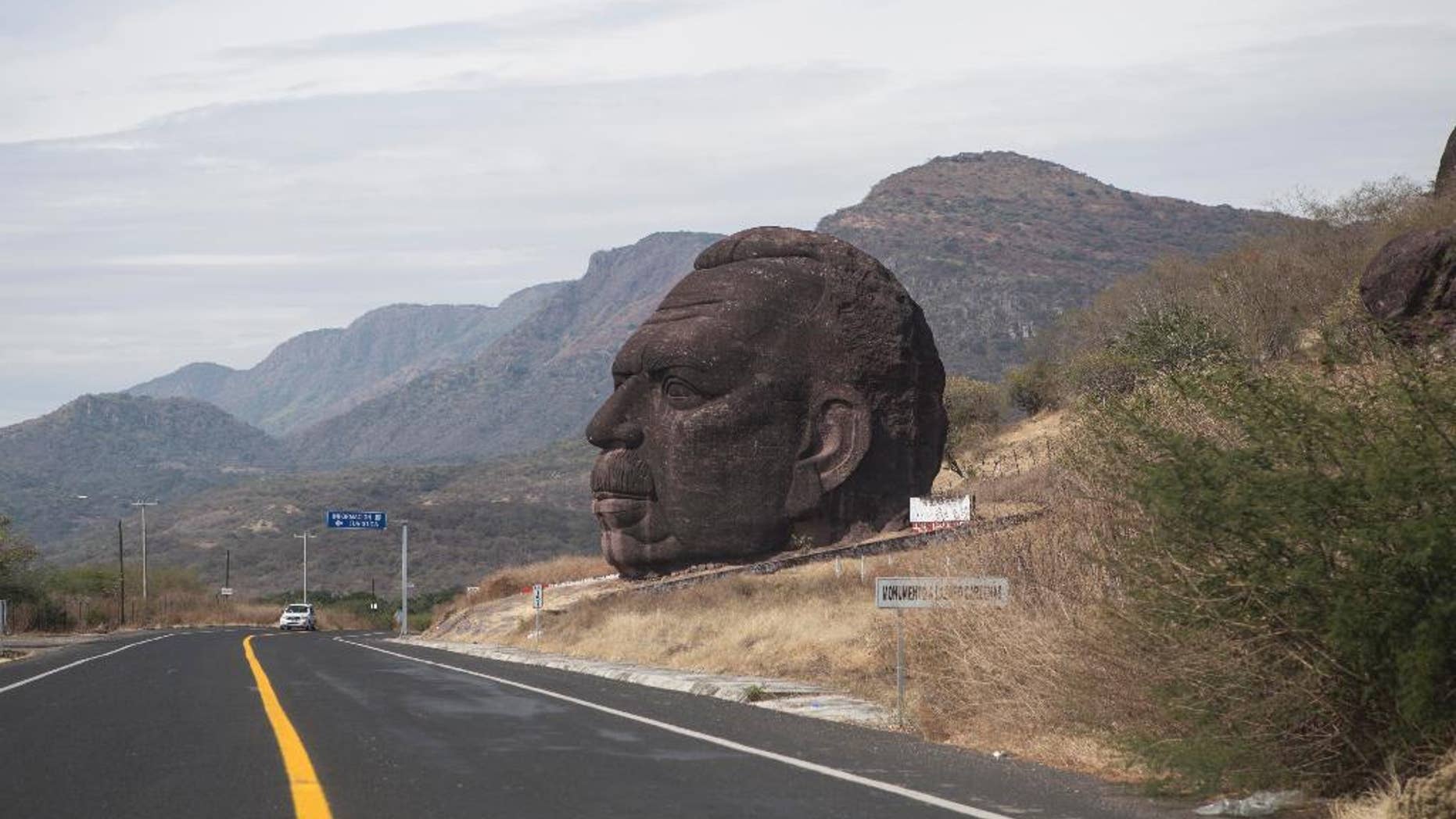 In this Tuesday, Dec. 23, 2014 photo, a monument in honor of Mexico's former President Lazaro Cardenas stands along a highway between Arcelia and Ciudad Altamirano on the state border of Guerrero and Michoacan, Mexico. The bishop of the diocese in Ciudad Altamirano said Friday, Dec. 26 that the Rev. Gregorio Lopez Gorostieta was found dead with a gunshot wound to the head, near this statue, on Christmas Day. Gorostieta disappeared on Monday from the seminary in the city where he taught. (AP Photo/Christian Palma)