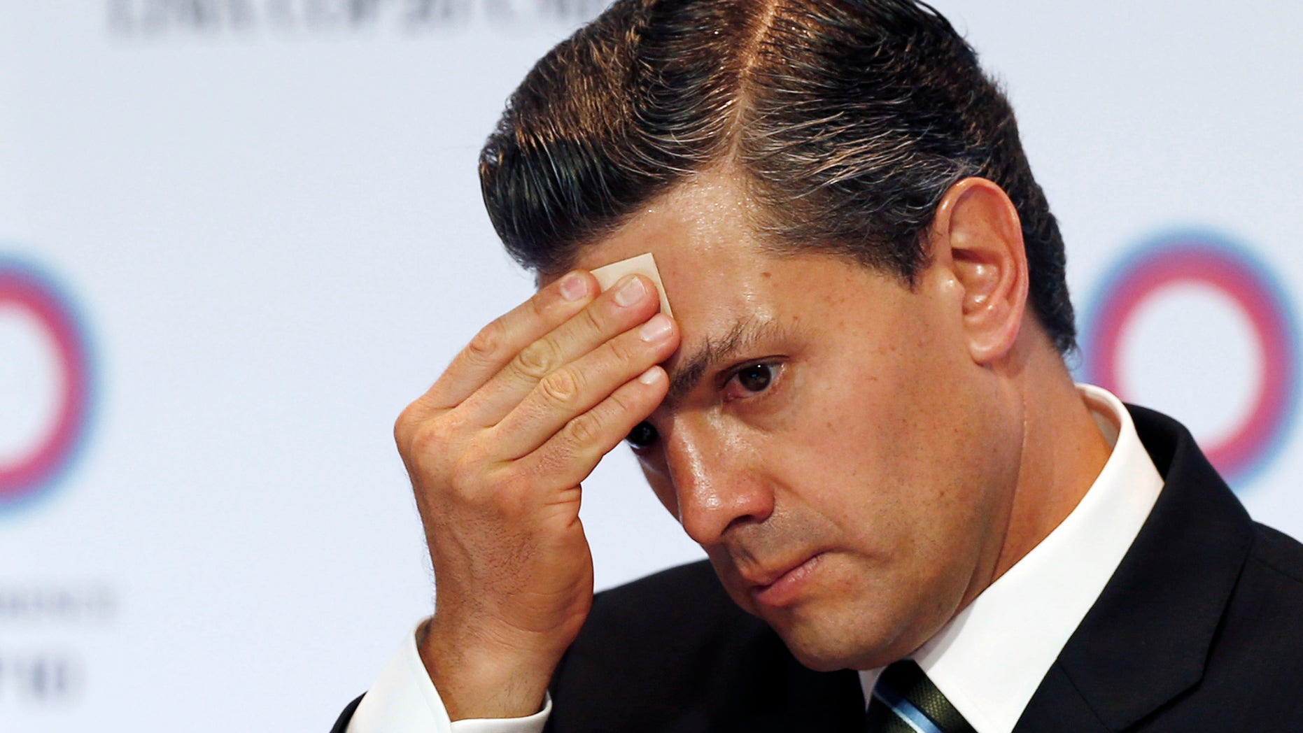 FILE - In this Dec. 10, 2014 file photo, Mexico's President Enrique Pena Nieto wipes sweat from his brow during a signing ceremony among the Pacific Alliance at the Climate Change Conference in Lima, Peru. The Mexican president and his team started 2014 carrying out a slew of newly passed reforms earning him international plaudits. Then came a 1-2-3 punch of scandals: Soldiers killing 22 civilians in a questionable shootout; the abduction and presumed murder of 43 college students, allegedly at the hands of local officials and police in league with a drug cartel; and revelations that Pena Nieto and his treasury secretary live in luxury homes built and financed by a favorite government contractor. (AP Photo/Juan Karita, File)