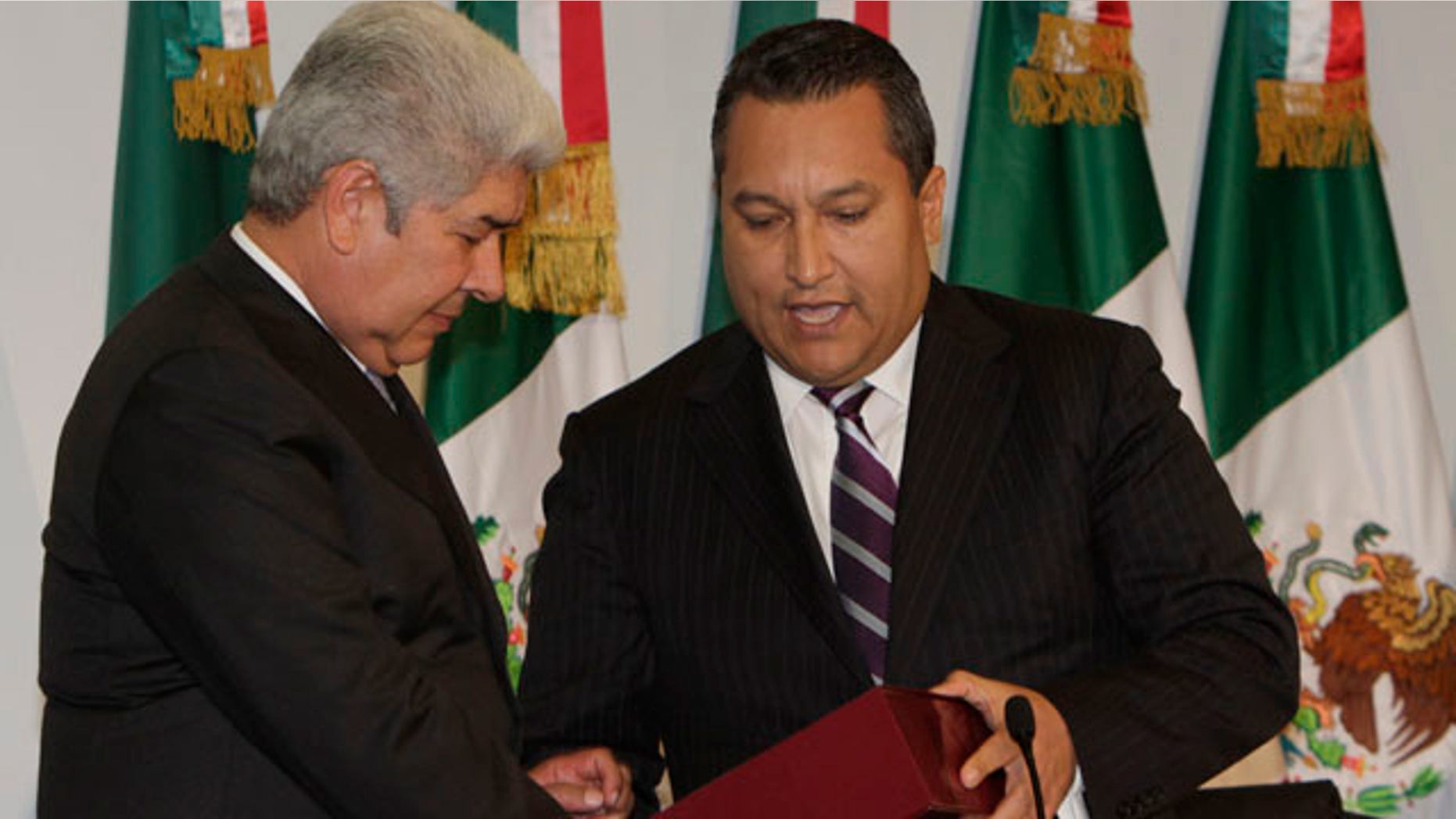 September 1: Mexico's Interior Secretary Jose Francisco Blake, hands the government's annual state of the nation report to Lower House President Francisco Ramirez Acuna at Congress in Mexico City. (AP)