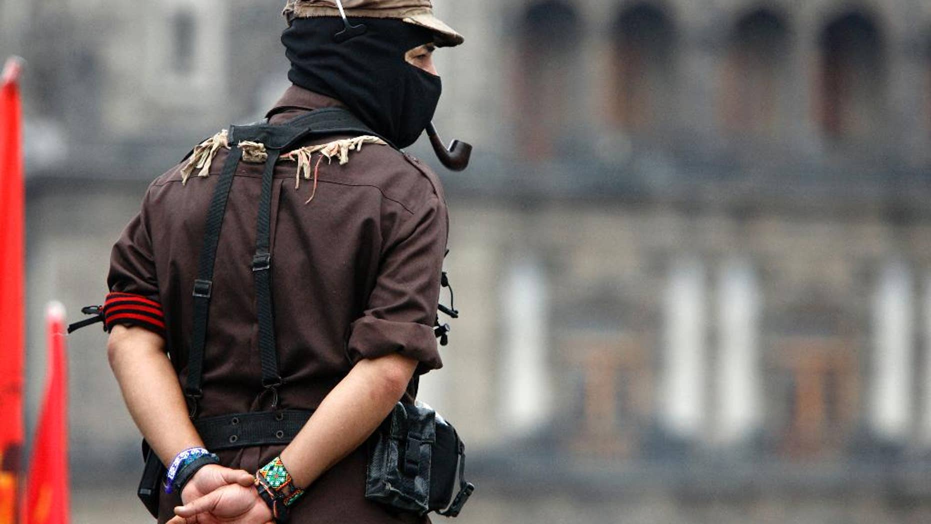 FILE - In this May 28, 2006 file photo, Subcomandante Marcos looks out into the Zocalo, Mexico City's main plaza, in Mexico. Marcos announced Sunday May 25, 2014, that he no longer is the official spokesperson of the Zapatista rebel movement. (AP Photo/Gregory Bull)