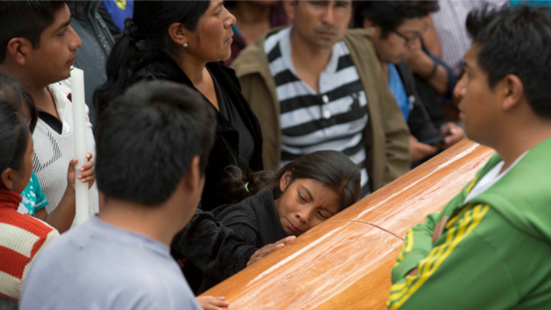 A girl embraces the coffin with the body of Yalid Jimenez, 29, who died yesterday during the clearing of the highway in Nochixtlan, Mexico, Monday, June 20, 2016. Violence erupted during the weekend in which six people died in confrontations between the police and striking teachers. The teachers are protesting against plans to overhaul the country's education system which include federally mandated teacher evaluations. (AP Photo/Eduardo Verdugo)