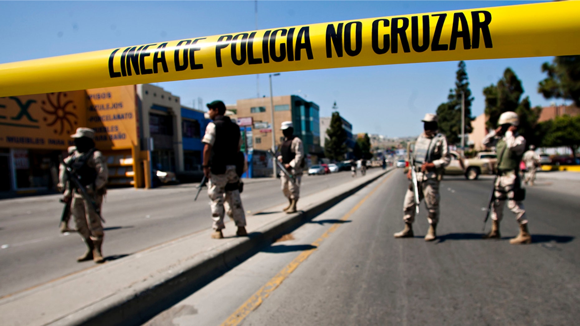 Mexican army soldiers guard the perimeter around the regional Attorney General's office after the early morning arrest of former Tijuana Mayor Jorge Hank Rohn in the city of Tijuana, Mexico, Saturday June 4, 2011. Hank Rhon, one of Mexico's most flamboyant businessmen and politicians, has been detained on suspicion of illegal weapons possession, the federal Attorney General's Office has announced. (AP Photo/Francisco Vega)