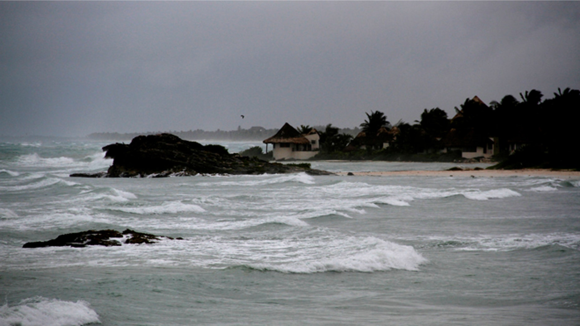 View of the beach in Tulum, Mexico, Tuesday, Aug. 7, 2012, as Tropical Storm Ernesto brings the threat of hurricane-force winds and torrential rains to the Caribbean coast. The heart of the storm was expected to hit south of Cancun and the Riviera Maya, though strong rain and winds were likely there, and officials prepared shelters there as a precaution. (AP Photo/Israel Leal)