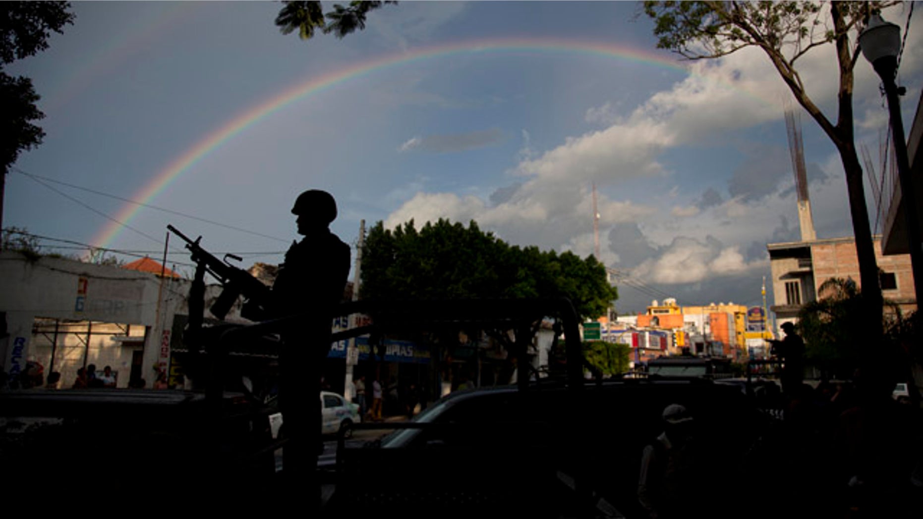 October 6, 2014: A soldier stands under a rainbow outside the municipality in Iguala, Mexico. Federal officials on Monday disarmed local police and took over security after an attack on students that left at least six dead and 43 missing. (AP Photo/Eduardo Verdugo)
