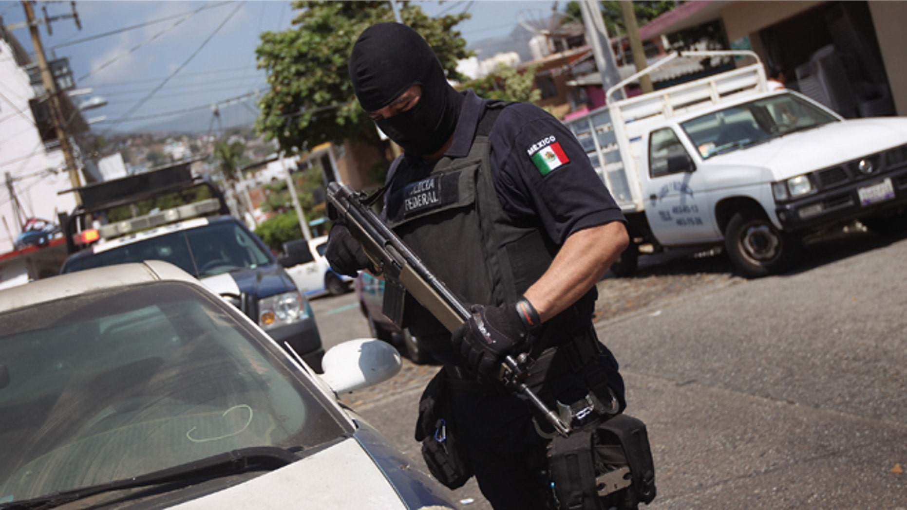 ACAPULCO, MEXICO - MARCH 01: A Mexican federal policeman inspects an abandoned car on March 1, 2012 in Acapulco, Mexico. Stolen vehicles used by drug gangs are often found abandoned throughout the city. Drug violence surged in the coastal resort last year, making Acapulco the second most deadly city in Mexico after Juarez. One of Mexico's top tourist destinations, Acapulco has suffered a drop in business, especially from foreign tourists, due to reports of the violence. Toursim accounts for some 9 percent of Mexico's economy and about 70 percent of the output of Acapulco's state of Guerrero. (Photo by John Moore/Getty Images)