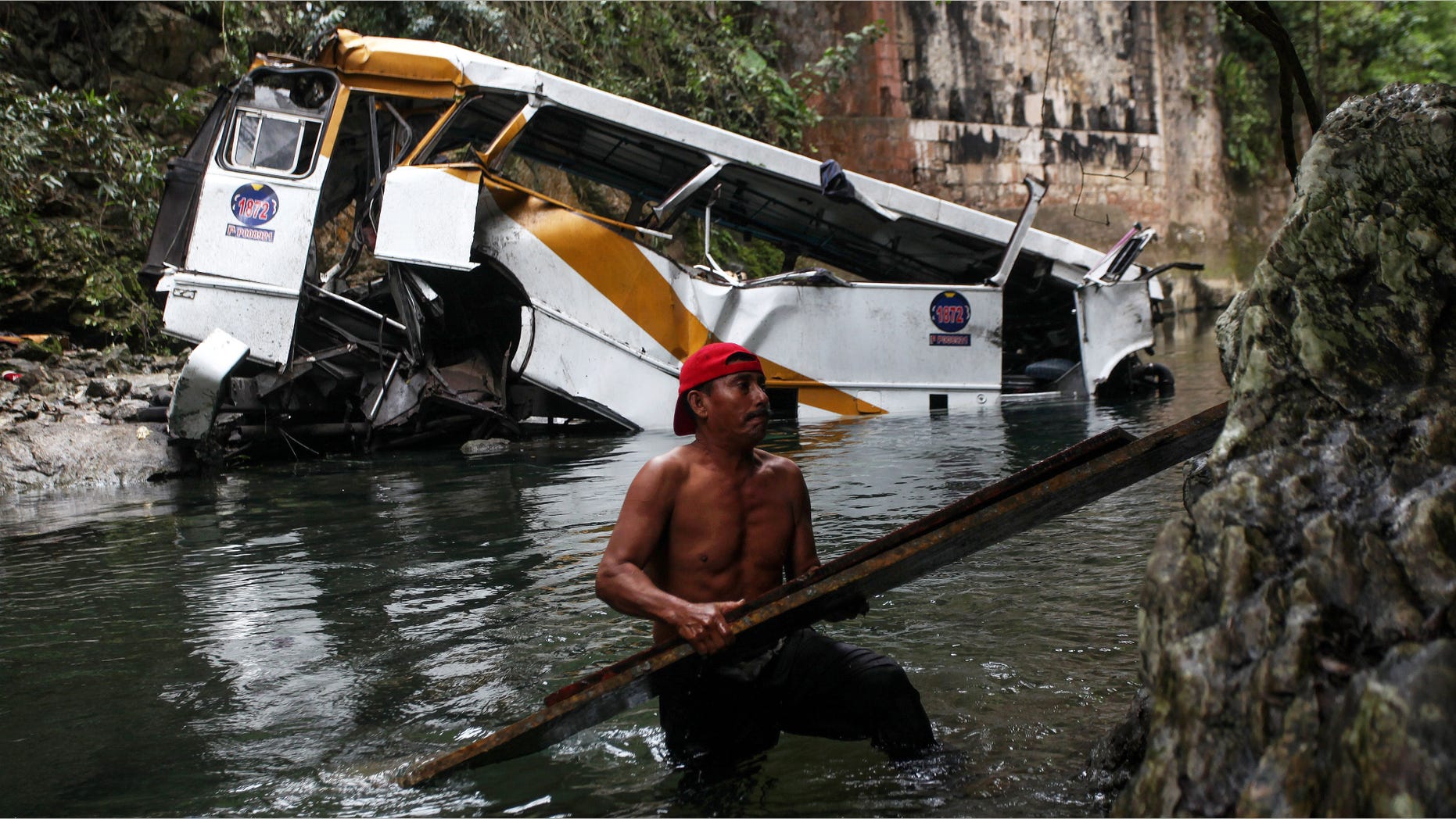 A passenger bus lays in a ravine after falling off the road in Atoyac, Veracruz state, Mexico, Sunday, Jan. 10, 2016. The bus, belonging to the Paso del Toro line, was carrying members of a football team and their relatives along the road connecting the cities of Camaron and Cordoba. According to authorities, at least 20 people were killed and 25 were injured. (AP Photo/Felix Marquez)