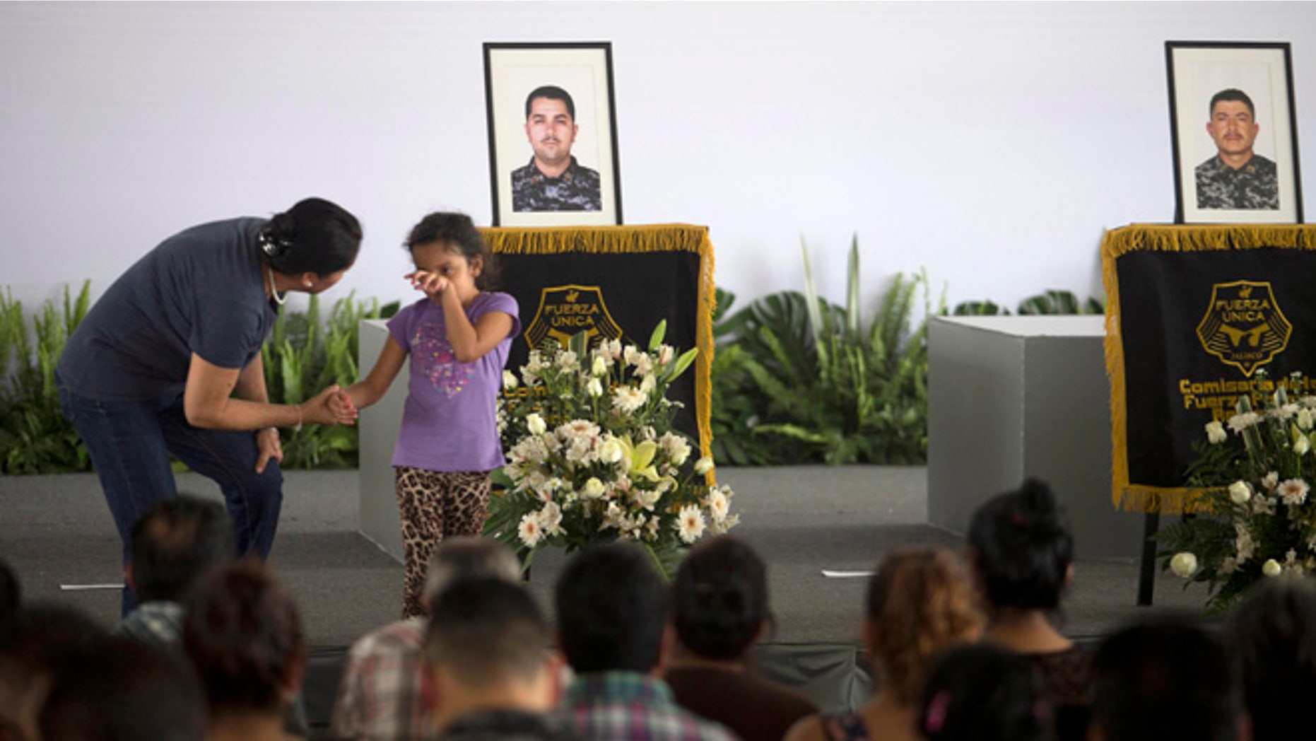 A girl weeps during a ceremony to honor slain policemen in Tlaquepaque, Mexico, Wednesday, April 8, 2015.
