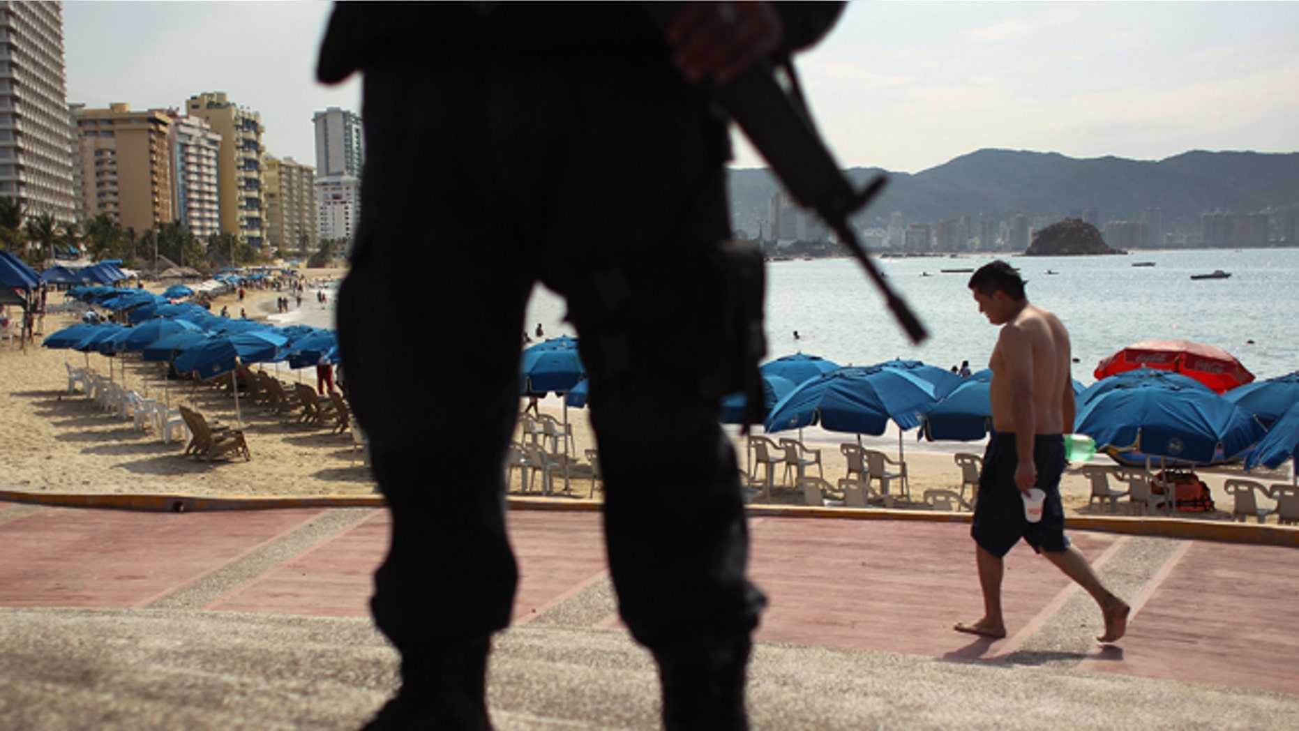ACAPULCO, MEXICO - MARCH 04: A Mexican federal policeman stands guard near the beach on March 4, 2012 in Acapulco, Mexico. Drug violence has surged in the coastal resort in the last year, making Acapulco the second most deadly city in Mexico after Juarez. One of Mexico's top tourist destinations, Acapulco has suffered a drop in business, especially from foreign tourists, due to the violence. Toursim accounts for about 70 percent of the economy of Acapulco's state of Guerrero and 9 percent of Mexico's economy. (Photo by John Moore/Getty Images)