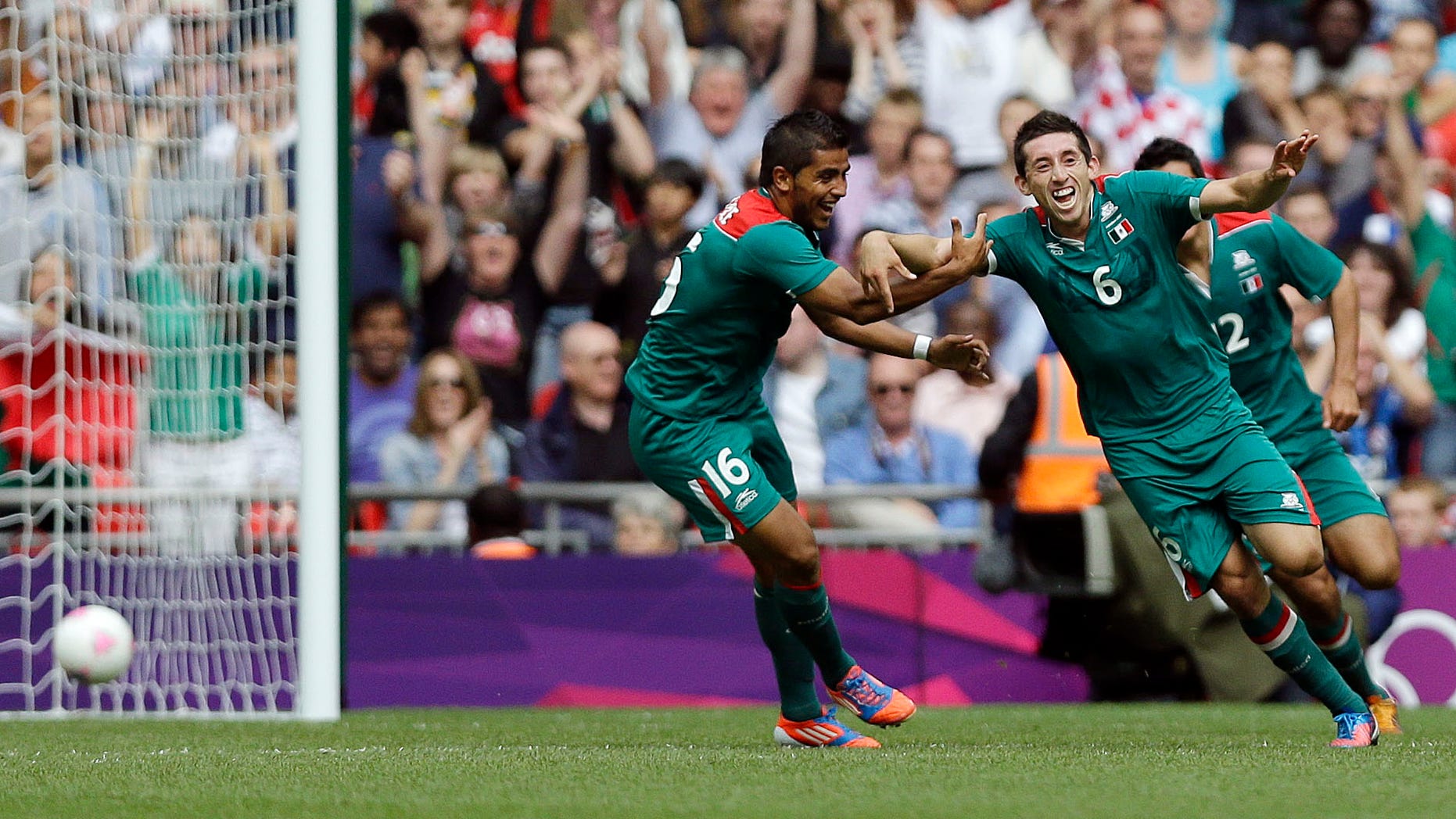 Mexico's Hector Herrera (6) celebrates with teammate Mexico's Miguel Ponce (16) after his goal against Senegal during their quarterfinal men's soccer match at the 2012 Summer Olympics, Saturday, Aug. 4, 2012, in London. Mexico won, 4-2. (AP Photo/Marcio Jose Sanchez)