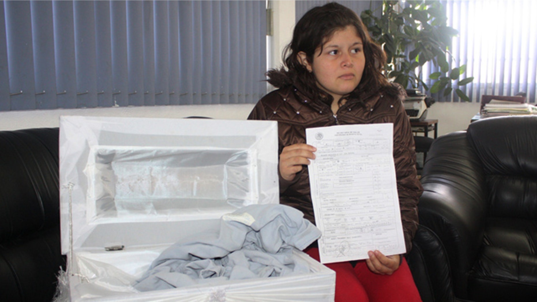 August 5: Dafne Hernandez, shows a death certificate of her newborn daughter and a coffin meant to be used at her burial during an interview with local media in Tulancingo, Mexico. (AP)