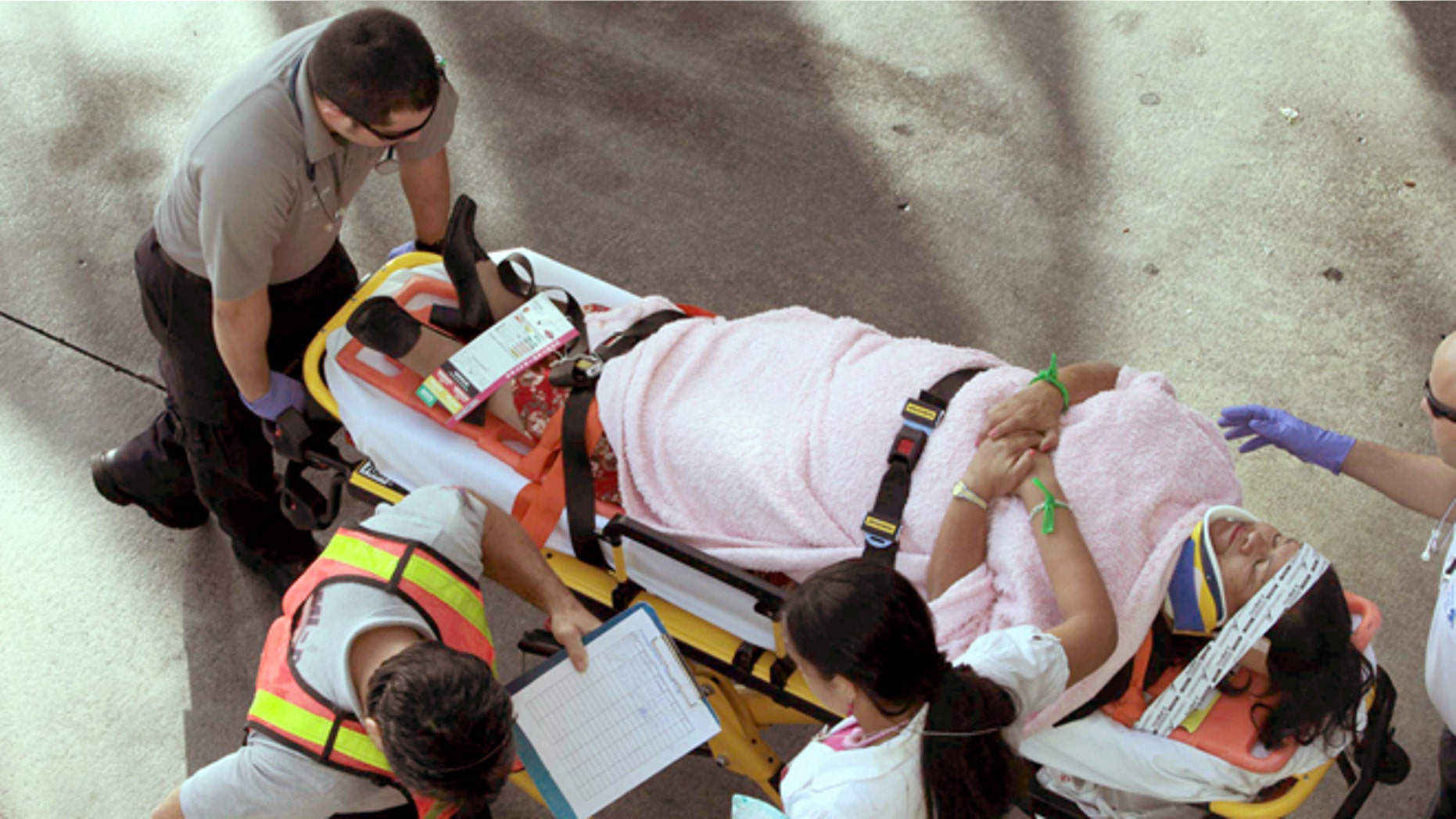 Emergency personnel attend to injured passengers after a bus accident at Miami International Airport on Saturday, Dec. 1, 2012 in Miami. Officials say a bus has hit an overpass, killing at least one person and injuring more than two-dozen people on board. Airport spokesman Greg Chin says the large, white bus hit the overpass going into the airport's arrivals section on Saturday morning. The bus was going about 20 mph when it clipped the roof entrance. (AP Photo/El Nuevo Herald, Roberto Koltun)