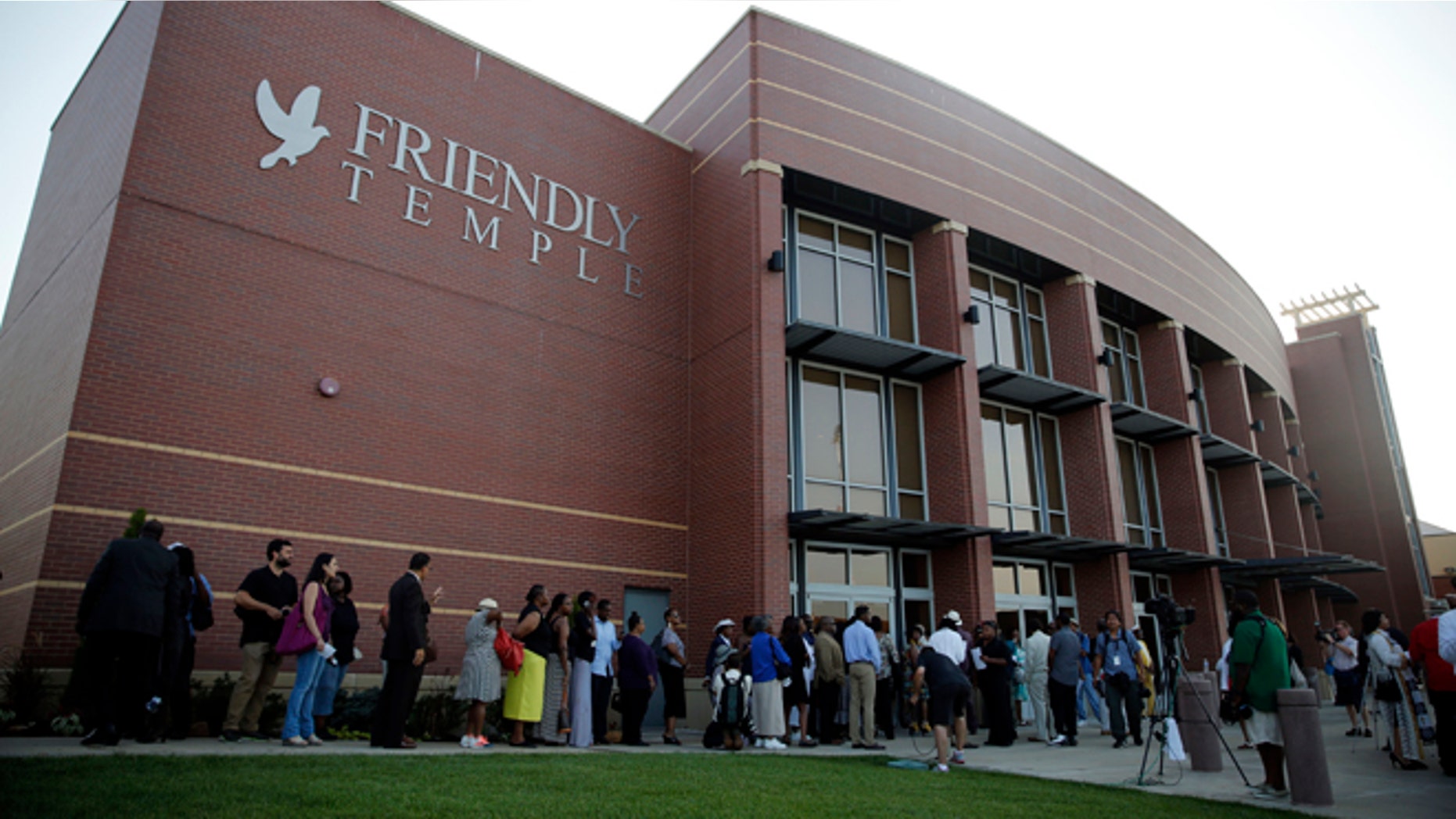 People begin to line up to attend the funeral for Michael Brown, Monday, Aug. 25, 2014, in St. Louis.