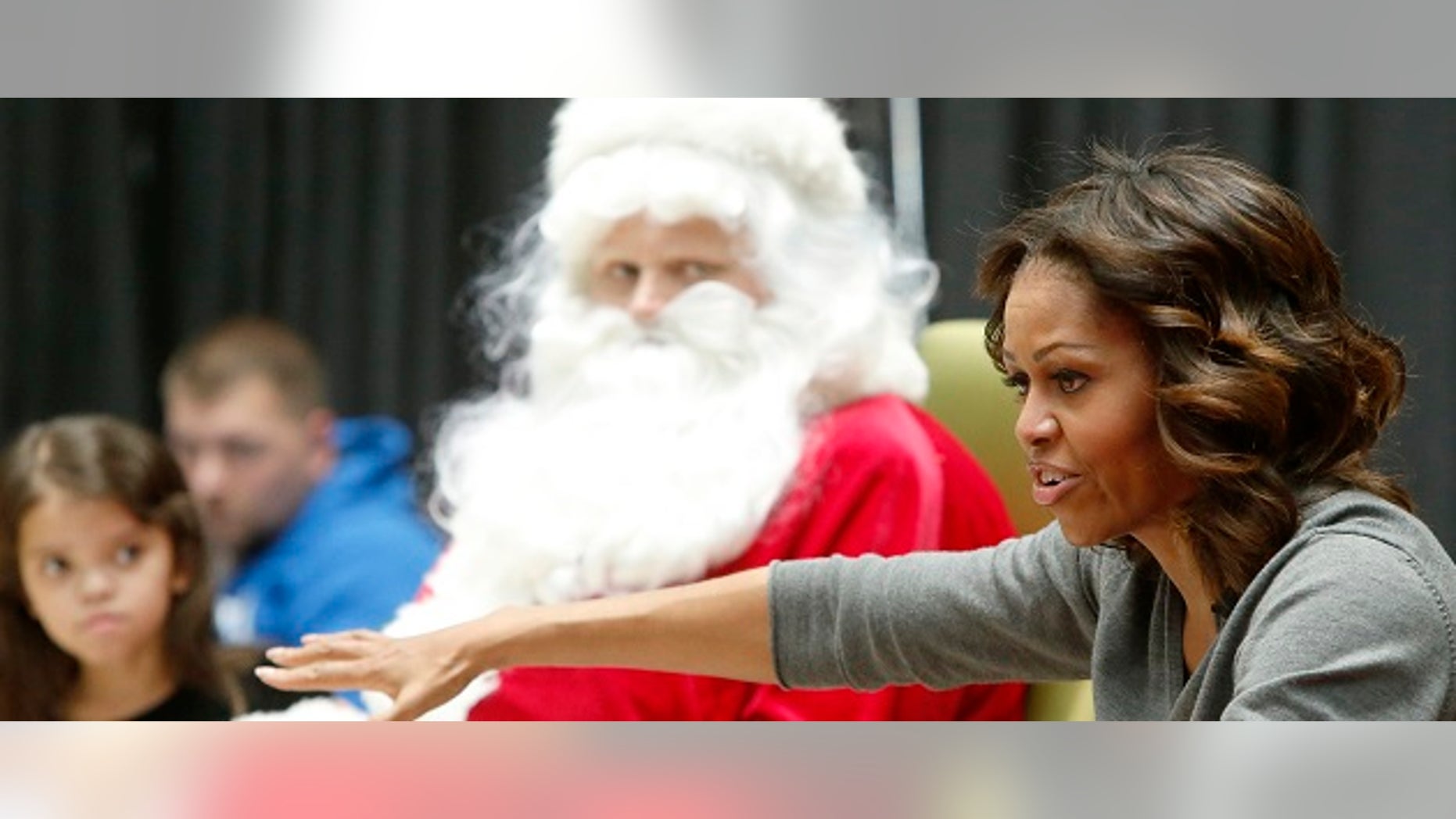 U.S. first lady Michelle Obama visits young patients and their families at the Children's National Medical Center in Washington, December 16, 2013. Obama read the book "'Twas the Night Before Christmas" before greeting the children along with Santa Claus and presidential dogs Sunny and Bo. REUTERS/Jonathan Ernst (UNITED STATES - Tags: POLITICS HEALTH ENTERTAINMENT SOCIETY) - RTX16LGE
