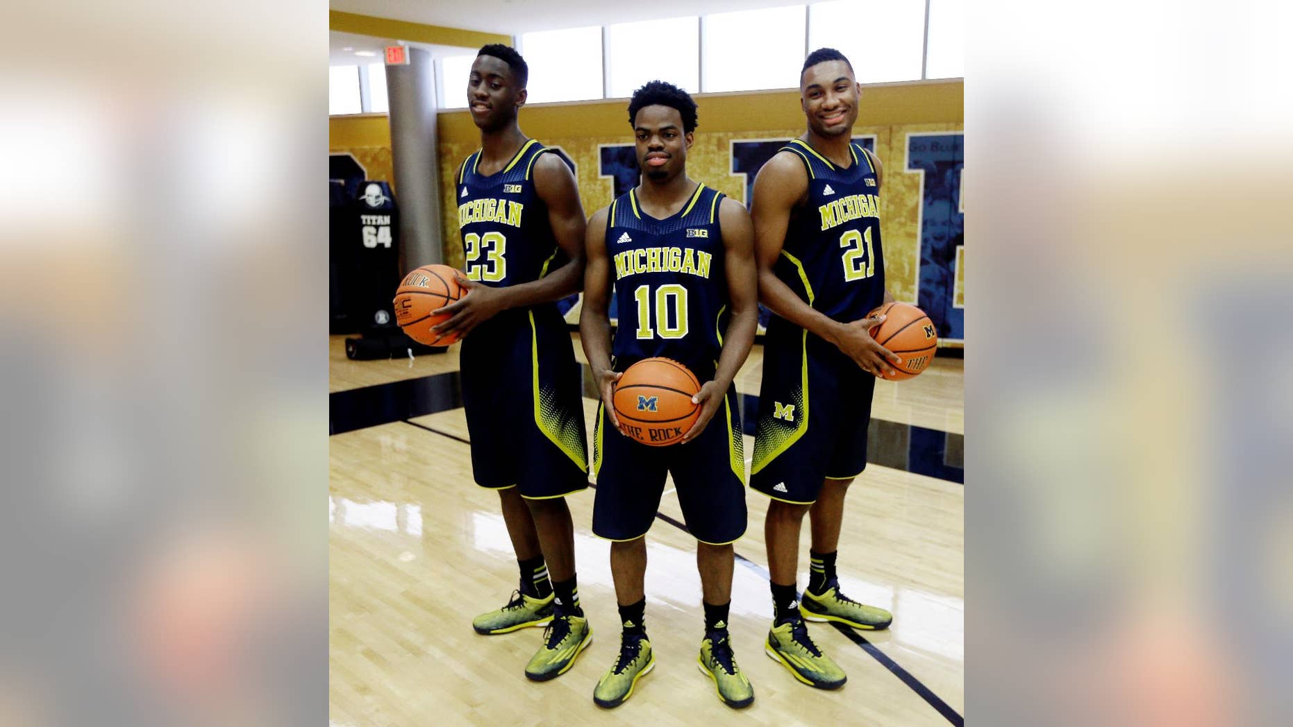 Michigan guard Caris Levert (23), Derrick Walton Jr., (10) and Zak Irvin (21) pose during the men's NCAA college basketball media day in Ann Arbor, Mich., Thursday, Oct. 30, 2014. (AP Photo/Carlos Osorio)