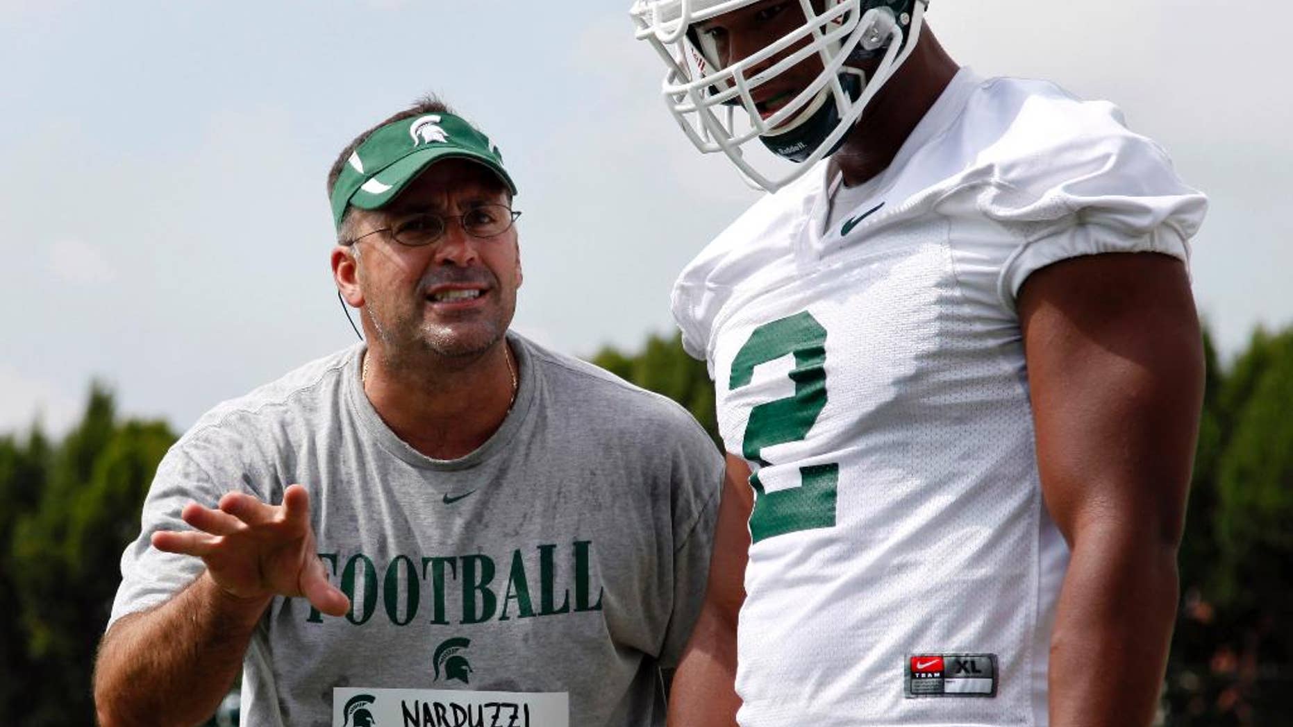 FILE - In this Aug. 7, 2011, file photo, Michigan State defensive coordinator Pat Narduzzi, left, gives instructions to defensive end William Gholston during the team's first NCAA college football practice of the season in East Lansing, Mich. Oregon is one of the toughest teams in the country to prepare for, but if anyone is up to the task, it may be Narduzzi, whose Spartans will take on the Ducks this weekend. (AP Photo/Al Goldis, File)