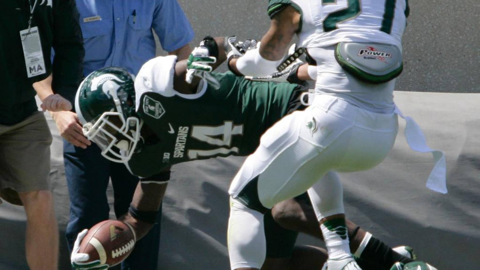 Green team receiver Tony Lippett (14) is pushed out of bounds by White team's Kurtis Drummond (27) during Michigan State's NCAA college spring football scrimmage on Saturday, April 26, 2014, in East Lansing, Mich. The White team won 20-13. (AP Photo/Al Goldis)