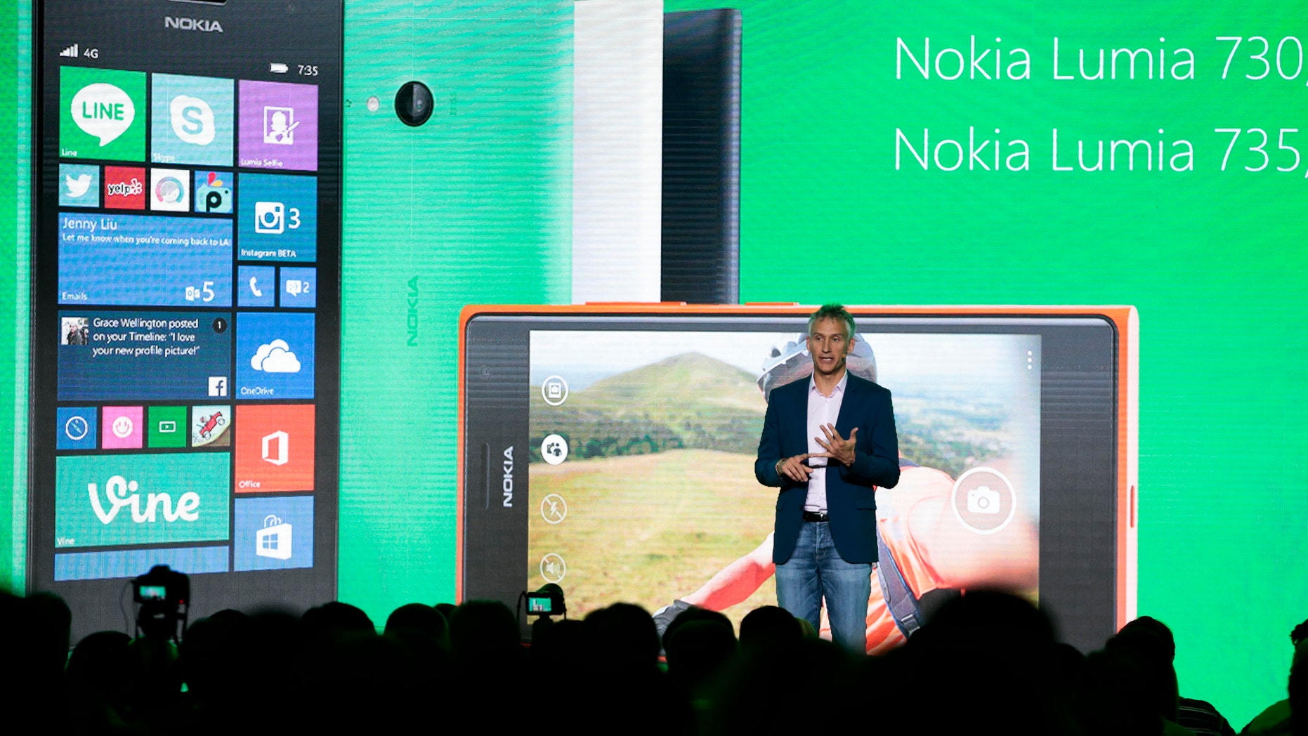 Chris Weber, CVP, Mobile Devices Sales of Microsoft presents the new Lumia 730 and 735 smart phones during his keynote speech at a Microsoft Nokia presentation event at the consumer electronic fair IFA in Berlin, Thursday, Sept. 4, 2014. (AP Photo/Markus Schreiber)