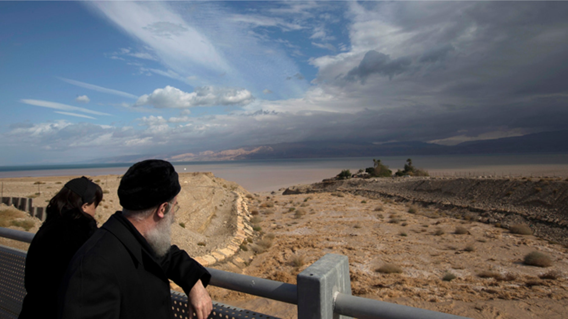 Jan. 9, 2013: A couple looks at water flowing into the Dead Sea during a flash flood near Kibbutz Ein Gedi.