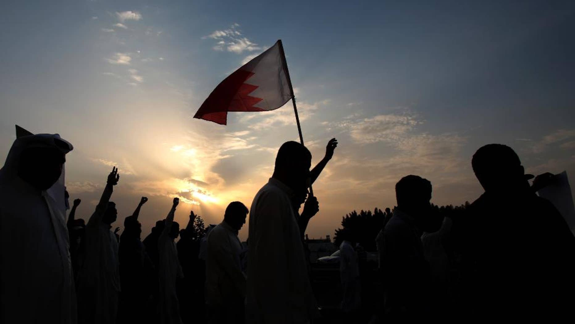 Thousands of Bahraini anti-government protesters, waving national flags and gesturing defiantly, chant slogans during a march organized by opposition groups in A'ali, Bahrain, Friday, April 18, 2014. A pro-democracy uprising of peaceful daytime marches and violent nighttime clashes simmers in its fourth year in the Gulf island kingdom. (AP Photo/Hasan Jamali)
