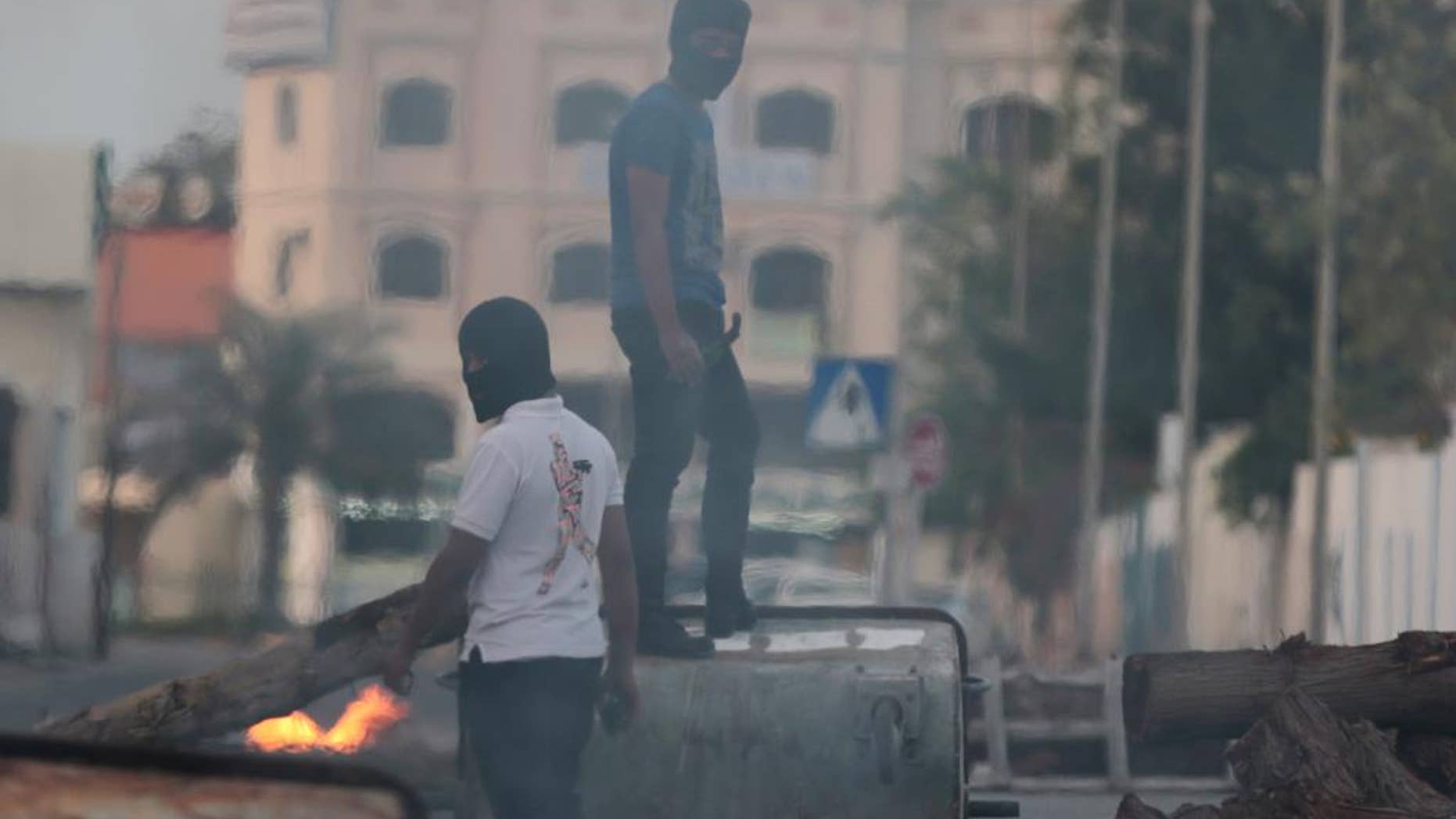 Bahraini anti-government protesters close roads with debris to slow riot police at the start of clashes in Shakoura, Bahrain, Friday, April 4, 2014. Clashes erupted after tens of thousands of the protesters carrying signs and images of jailed political leaders marched in Saar, Bahrain. Protesters also raised signs against the Formula One Bahrain Grand Prix, which is being held Sunday in the Gulf island kingdom. (AP Photo/Hasan Jamali)