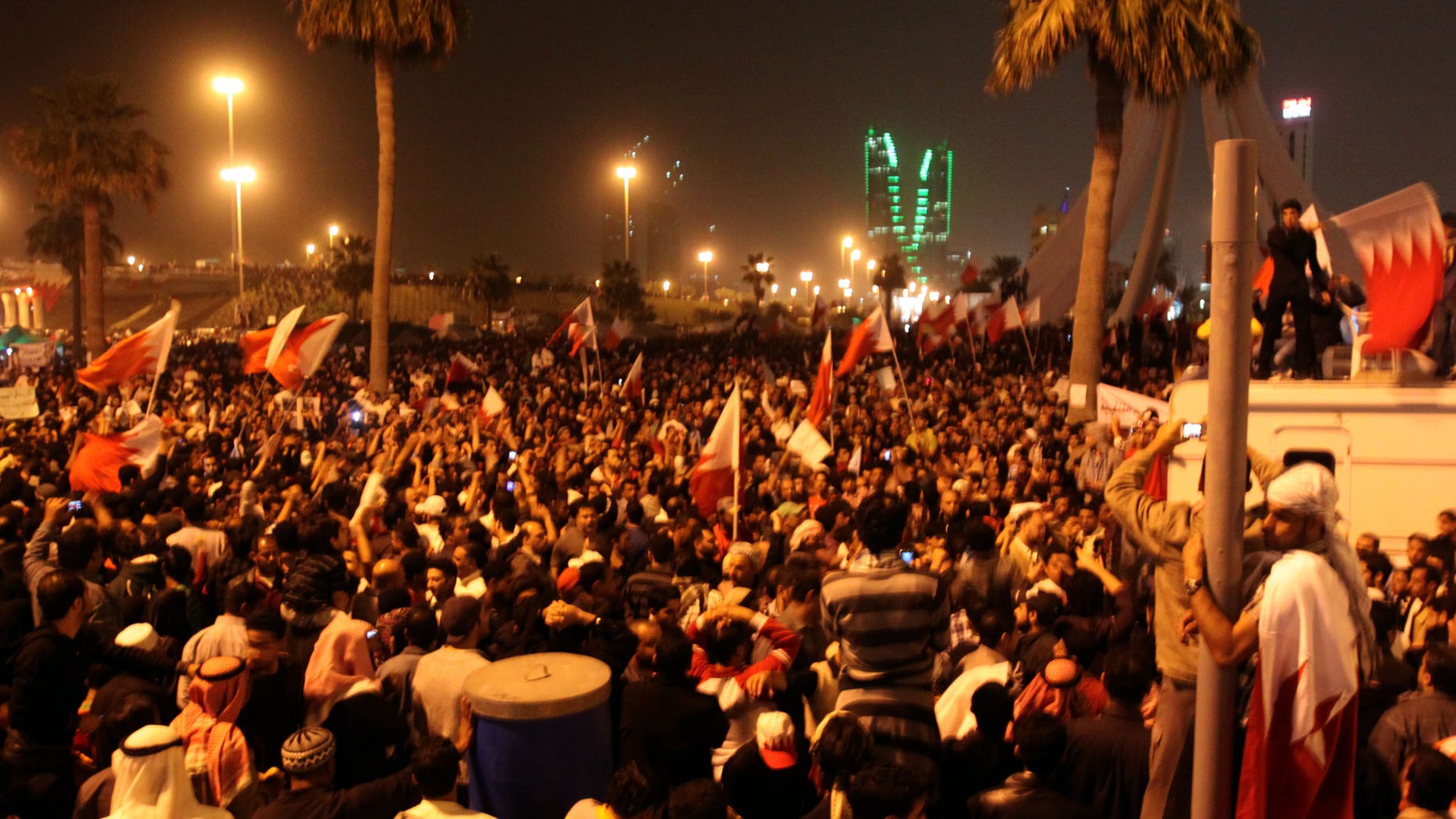 Feb. 16: Bahraini anti-government protesters wave flags in a demonstration at the Pearl roundabout, in Manama, Bahrain. In the background are the twin towers of the Bahrain Financial Harbour.