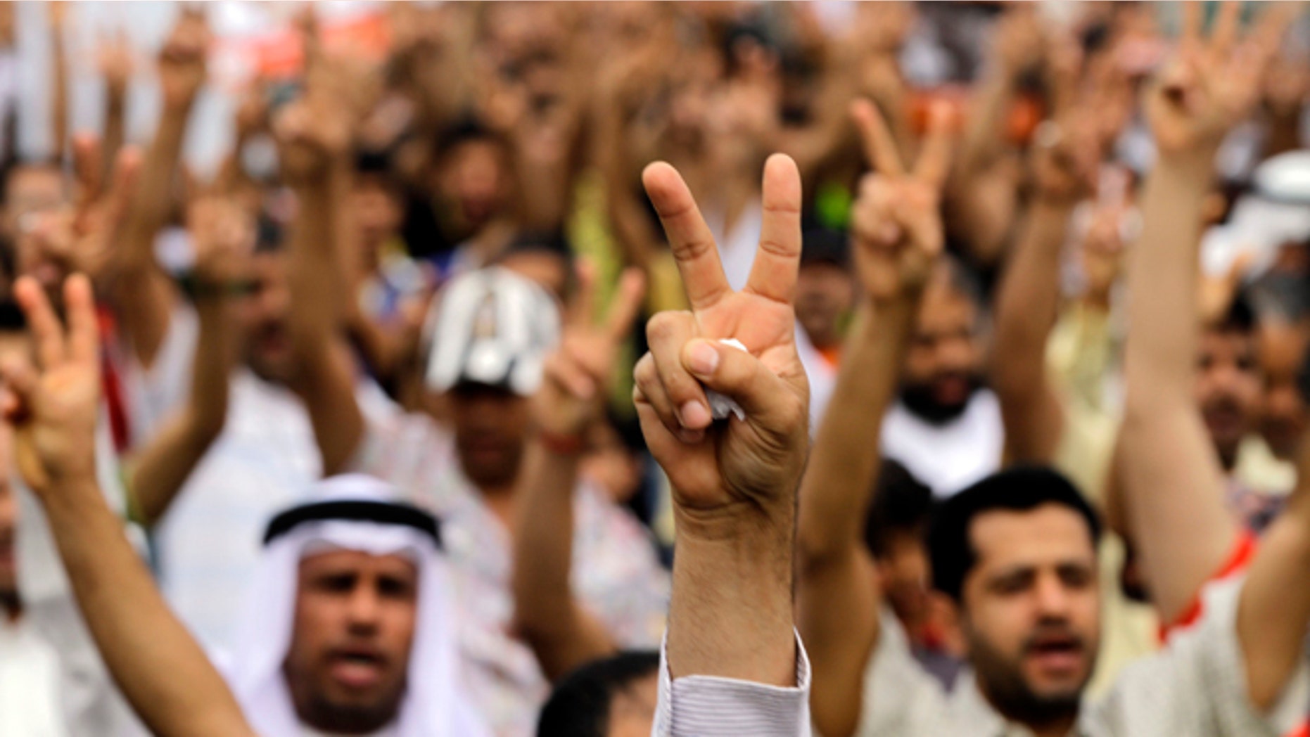 April 21, 2012: Bahraini anti-government protesters gesture as they march in Diraz, Bahrain, west of the capital of Manama.