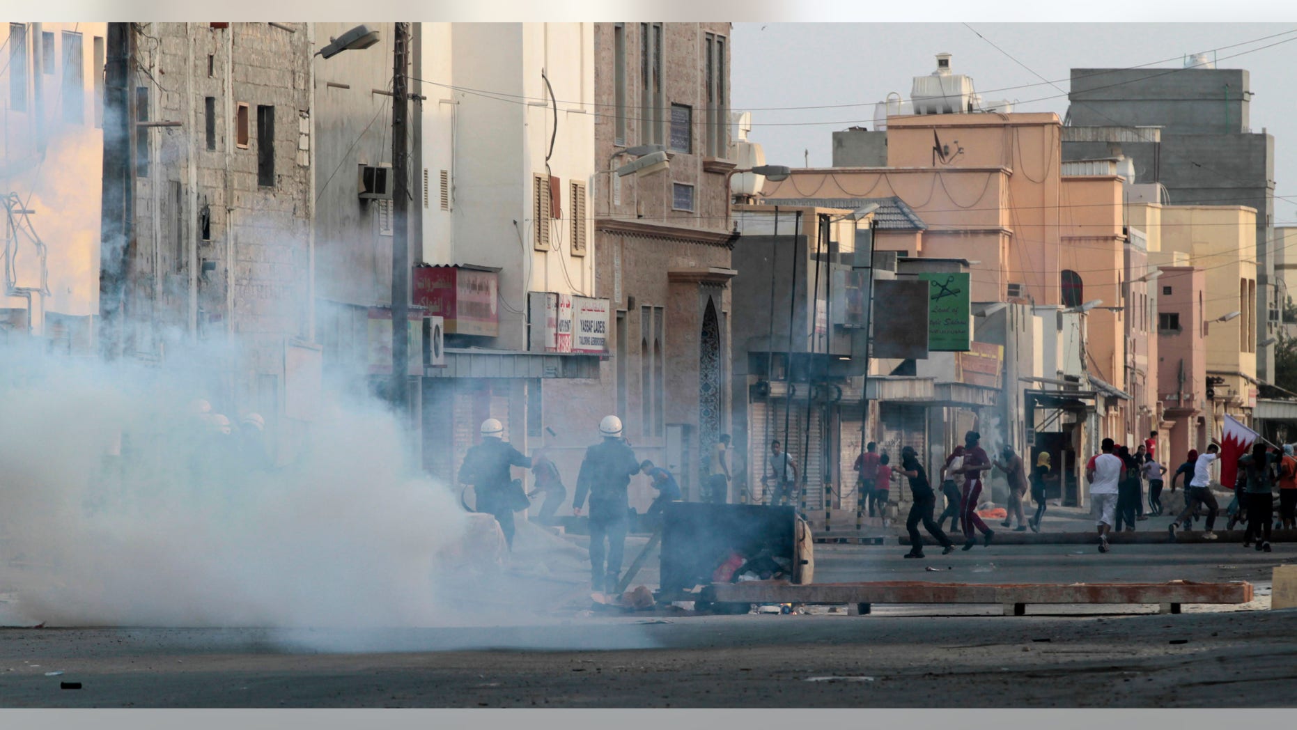 Riot police fire tear gas toward Bahraini anti-government protesters throwing stones and petrol bombs during clashes in Ma'ameer, Bahrain, Sunday, Oct. 21, 2012. Demonstrators were trying to break past police to enter a village under a security clampdown just across a highway. Authorities in Bahrain detained the daughter of a jailed opposition leader and two other activists Sunday seeking to enter a village under a security clampdown following a bombing last week that killed a policeman. (AP Photo/Hasan Jamali)
