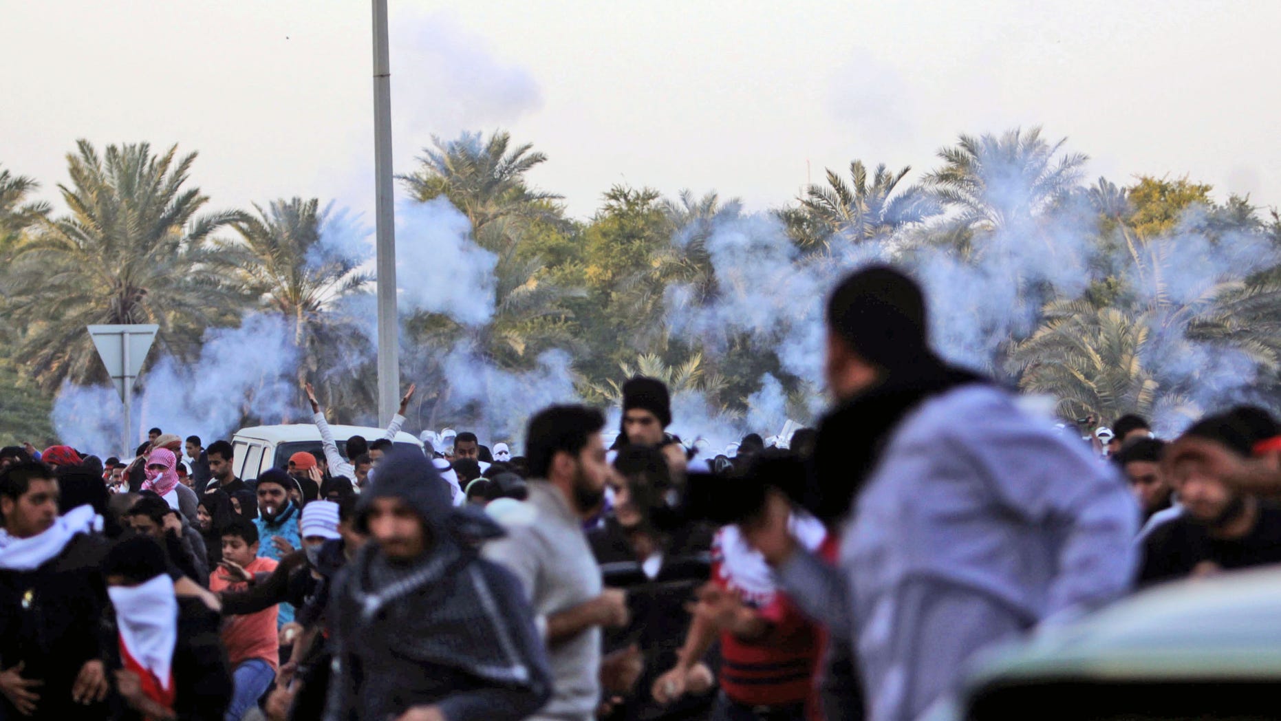 DEc. 23, 2011: Anti-government protesters run as riot police begin firing tear gas.