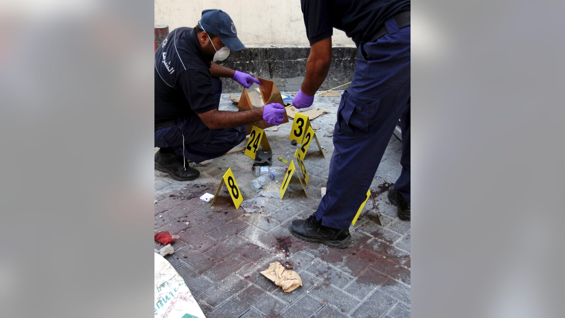 Monday, Nov. 5, 2012 - Police collect evidence at the scene of an explosion that killed an Asian man in Manama, Bahrain.