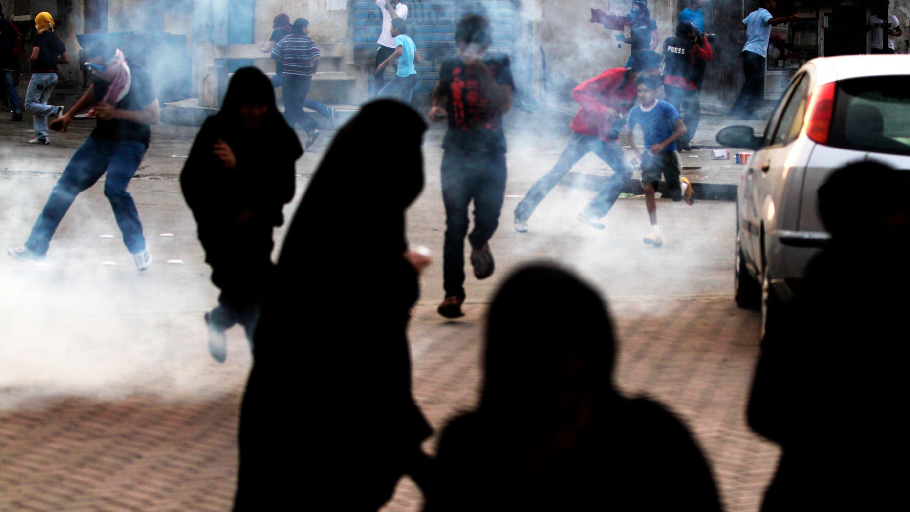 April 10, 2012: Bahraini anti-government protesters run from tear gas fired by riot police in Bilad al-Qadeem, Bahrain, on the edge of the capital of Manama, where demonstrators gathered in support of jailed Bahraini political leaders.