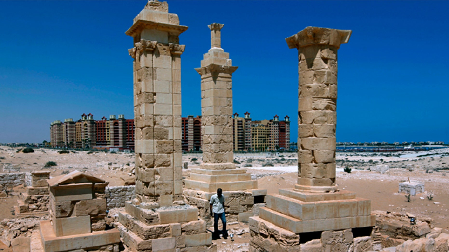 With a five star hotel in the background, a man walks by restored Roman pillar tombs of the ancient city of Leukaspis a well known Greco-Roman port overlooking the Mediterranean Sea at the costal resorts of Marina, Egypt Sunday, Aug. 29, 2010. Today, it's a sprawl of luxury vacation homes where Egypt's wealthy play on the white beaches of the Mediterranean coast. But 2,000 years ago, this was a thriving Greco-Roman port city, boasting villas of merchants grown rich on the wheat and olive trade.