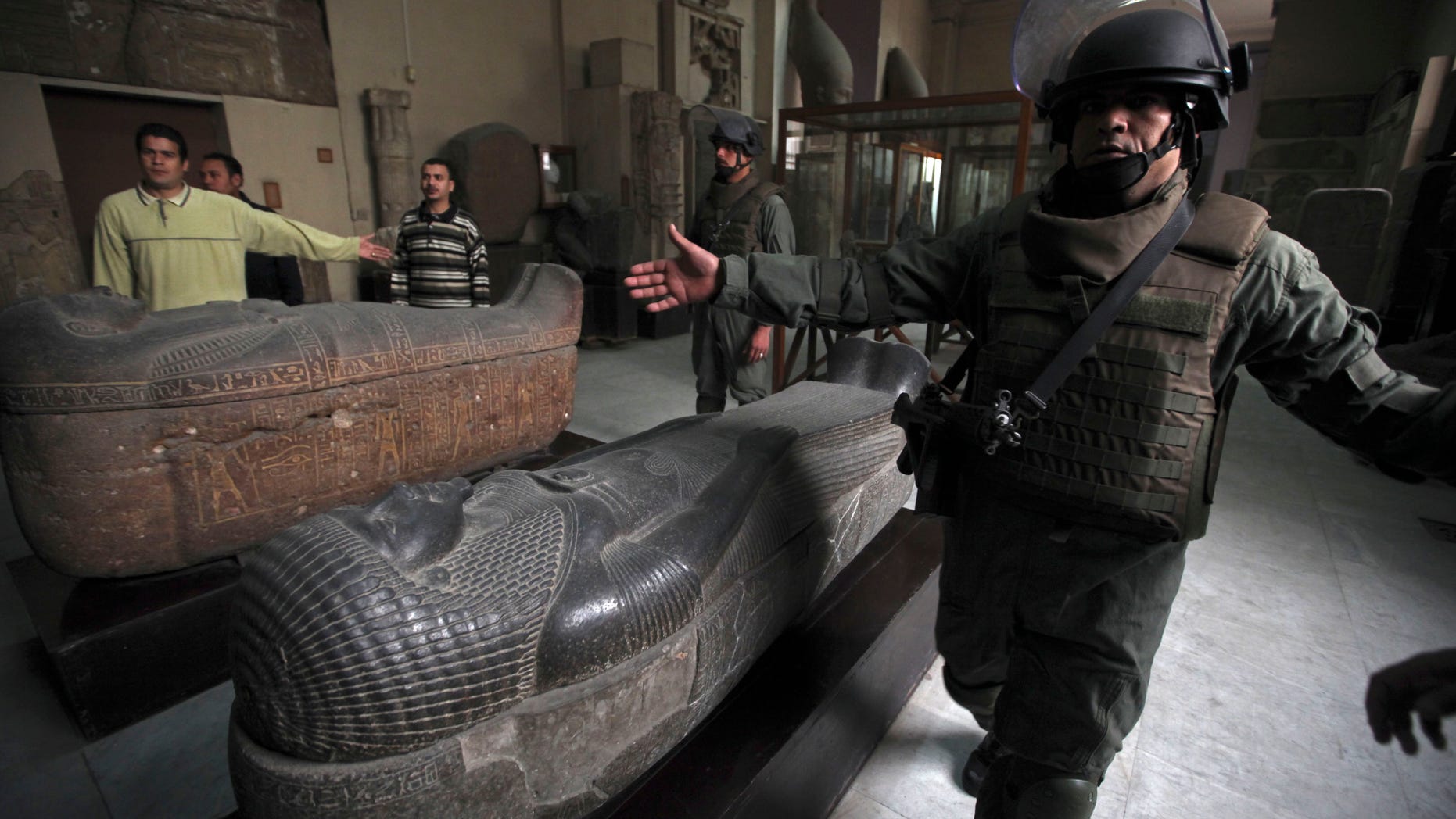 In this file photo, Army special forces gesture as they escort journalists during a tour for the media in the Egyptian Museum in Cairo. Taking advantage of Egypt's political upheaval, thieves have gone on a treasure hunt with a spree of illegal digging, preying on the country's ancient pharaonic heritage.