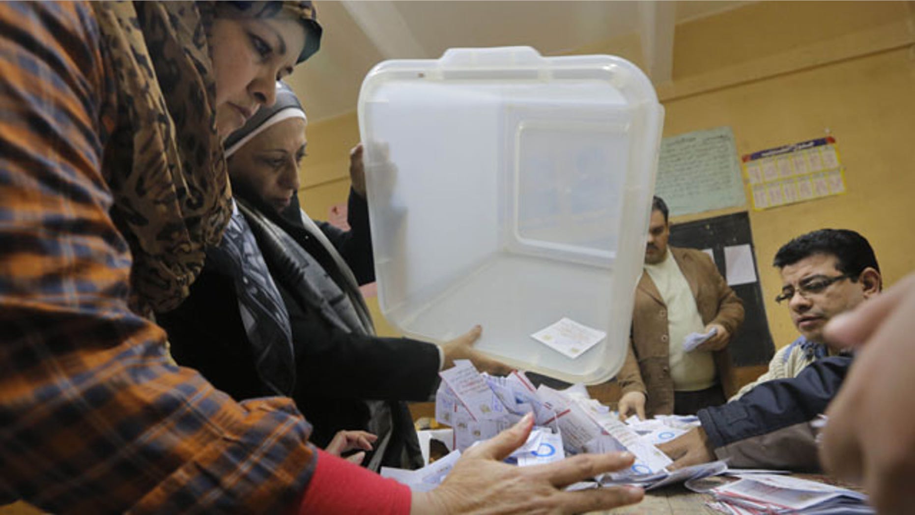 January 15, 2014: Election workers empty a ballot box at the end of the second, final day of a key referendum on a new constitution, inside a polling station in Cairo, Egypt.