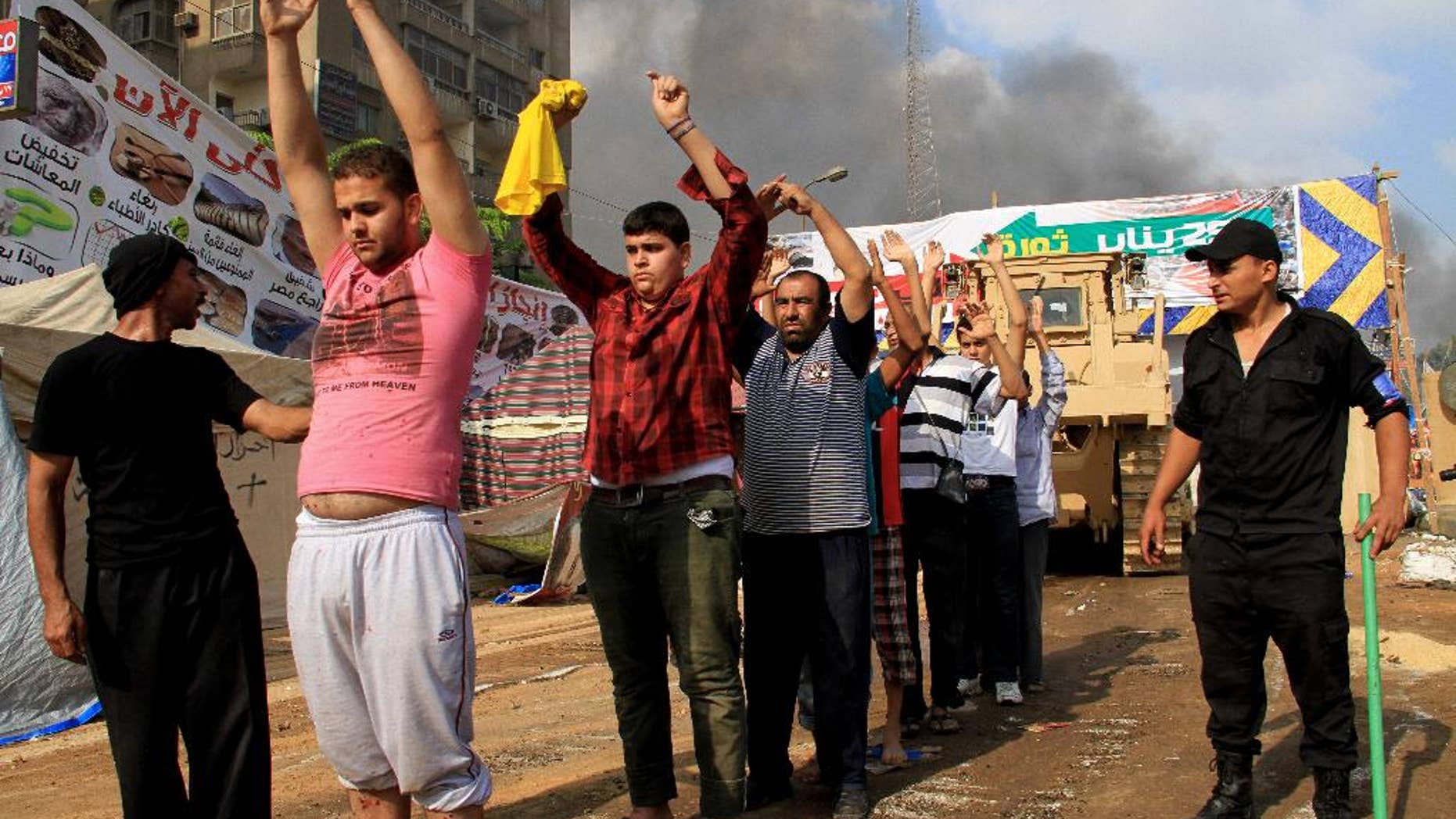 FILE - In this Wednesday, Aug. 14, 2013 file photo, Egyptian security forces detain protesters as they clear a sit-in by supporters of ousted Islamist President Mohammed Morsi in the eastern Nasr City district of Cairo. The scene on Aug. 14, 2013, was the start of the biggest massacre in modern Egyptian history, as security forces crushed the sit-in by Islamist supporters of Mohammed Morsi, the elected president who had been removed by the military a month earlier. At least 624 people were killed during 12 hours of mayhem in Cairo’s Rabaah el-Adawiyah Square, though rights groups have said the toll may be several hundred higher. (AP Photo/Ahmed Gomaa, File)