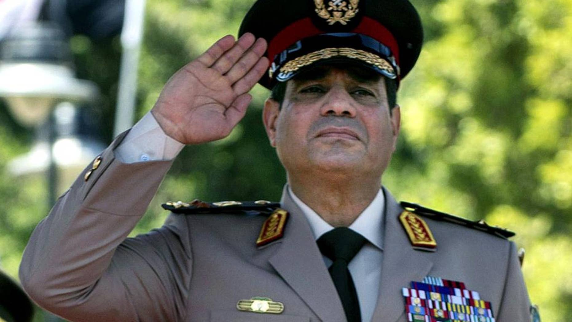 FILE - In this Wednesday, April 24, 2013 file photo, Gen. Abdel-Fattah el-Sissi of Egypt's Defense Minister salutes during an arrival ceremony for U.S. Secretary of Defense Chuck Hagel at the Ministry of Defense in Cairo, Egypt. On Saturday, March, 8, 2014 interim Egyptian President Adly Mansour issued a law regulating the upcoming election, which is expected to be held by the end of April. As he nears announcing a run for Egypt’s presidency, El-Sissi has been focusing on preparing an economic program, senior generals and government officials say, demonstrating the wariness within the military over the scale of problems facing the country. (AP Photo/Jim Watson, Pool, File)