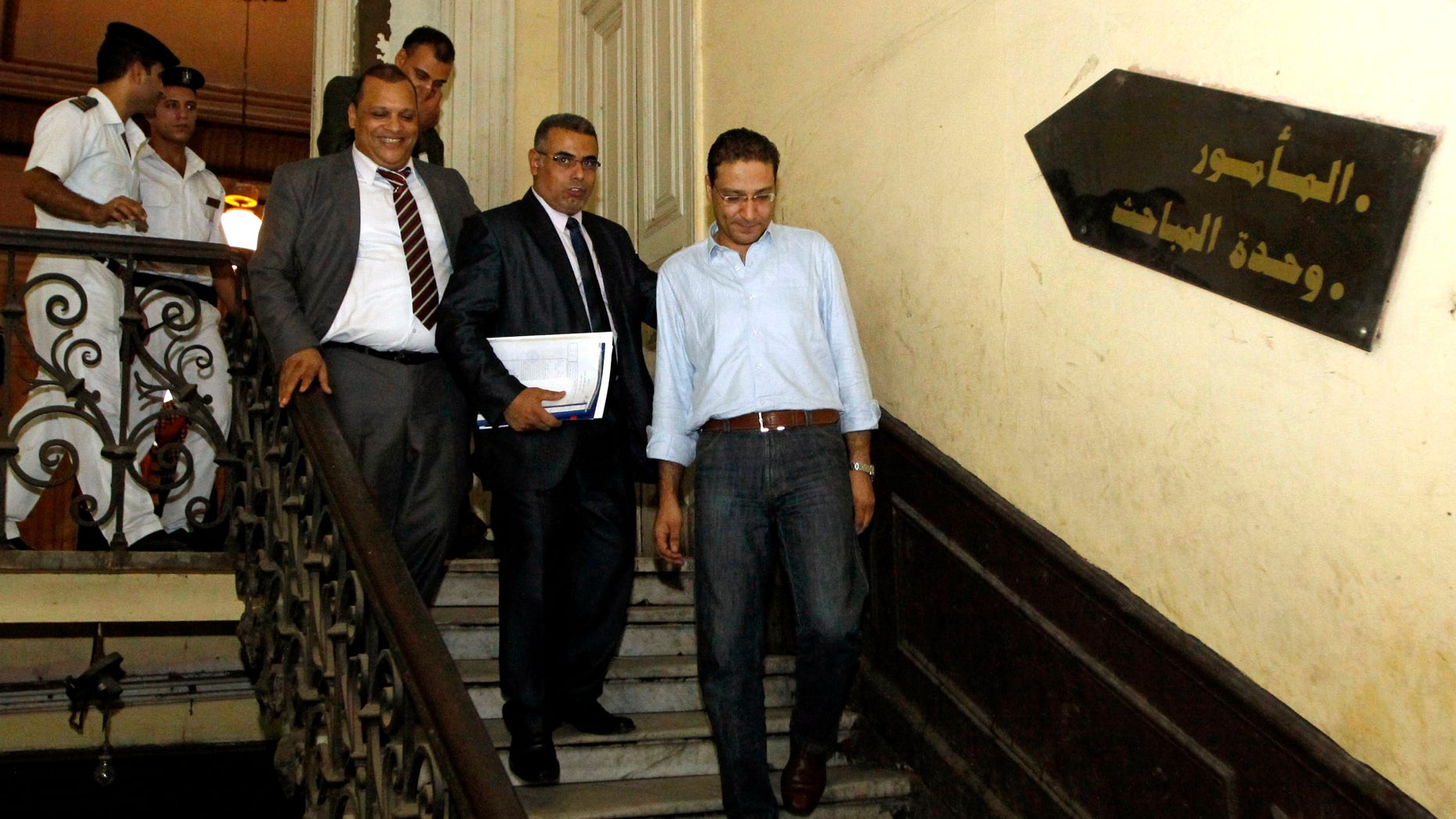In this Thursday, Aug. 23, 2012 photo, Newspaper editor Islam Afifi, right, walks out of a Cairo police station hours after a court had ordered Afifi to remain in prison pending trial in September over accusations of slandering the president and harming public interest for inflammatory articles published in el-Dustour newspaper in Cairo, Egypt. Hours after the court decision was announced, President Mohammed Morsi passed his first law since assuming lawmaking powers banning the imprisonment of journalists who face trial on media-related charges. (AP Photo/Ahmed Abd el Fatah