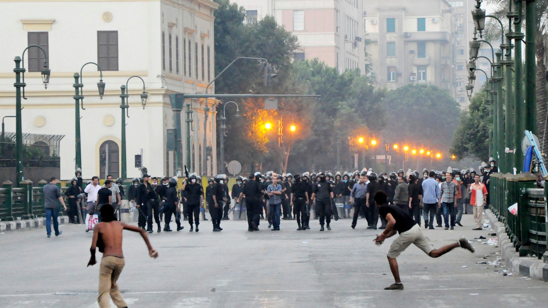 Sept. 15, 2012: Egyptian protesters hurl stones at riot police in downtown Cairo, Egypt, before police cleared the area after days of protests against a film ridiculing the Prophet Muhammad.