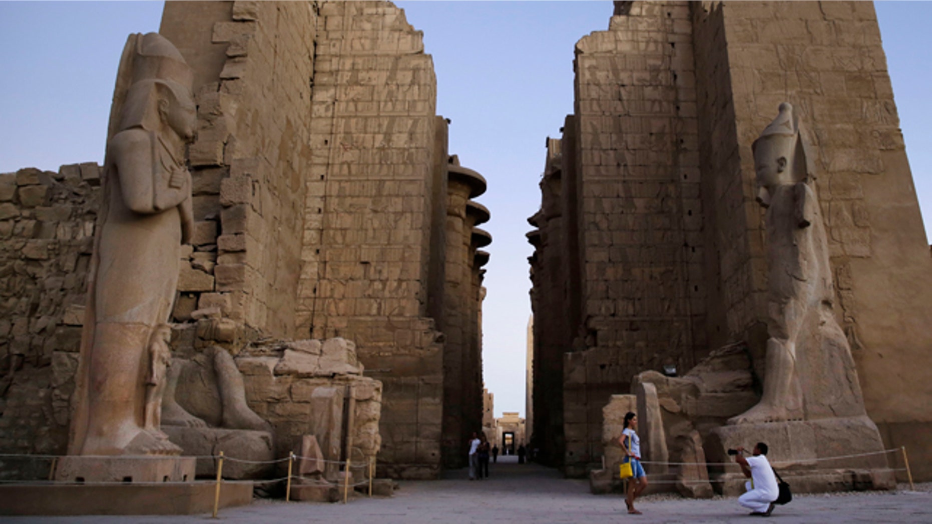 FILE - In this Sunday, Nov. 30, 2014, file photo a tourist has her picture taken at the ruins of the Karnak Temple in Luxor, Egypt. Egyptian officials say a suicide bomber has blown himself up at the ancient temple of Karnak in Luxor, a southern city frequented by millions of foreign and Egyptian tourists every year. (AP Photo/Hassan Ammar, File)