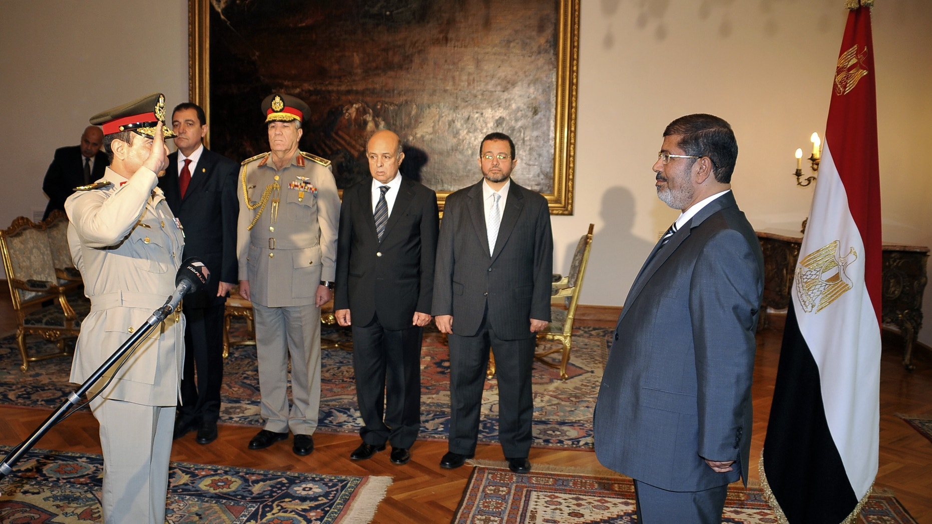 RETRANSMISSION FOR ALTERNATIVE CROP - Egyptian President Mohammed Morsi, right, swears in newly-appointed Minister of Defense, Lt. Gen. Abdel-Fattah el-Sissi, left, in Cairo, Egypt, Sunday, Aug. 12, 2012. Egypt's Islamist president ordered his former defense minister and chief of staff to retire on Sunday and canceled the military-declared constitutional amendments that gave top generals wide powers. (AP Photo/Egyptian Presidency)
