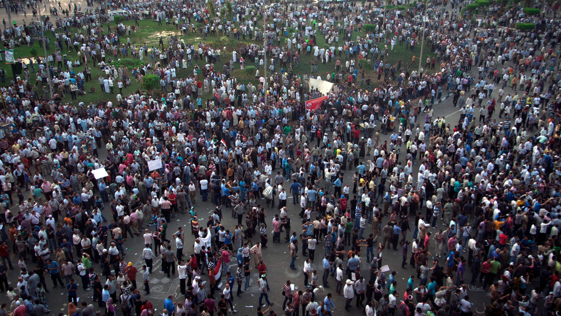 Protesters gather in Tahrir square in Cairo, Egypt, Friday, Oct. 12, 2012. Thousands of supporters and opponents of Egypt's new Islamist president clashed in Cairo's Tahrir Square on Friday, hurling stones and concrete and swinging sticks at each other in the first such violence since Mohammed Morsi took office more than three months ago.(AP Photo/Khalil Hamra)