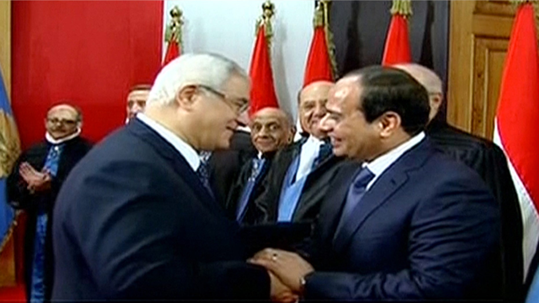 June 8, 2014: This image made from Egyptian State Television shows newly sworn in President Abdel-Fattah el-Sissi, right, being congratulated by outgoing interim President Adly Mansour, center left, after a ceremony at the Supreme Constitutional Court in Cairo, Egypt. (AP Photo/Egyptian State Television)