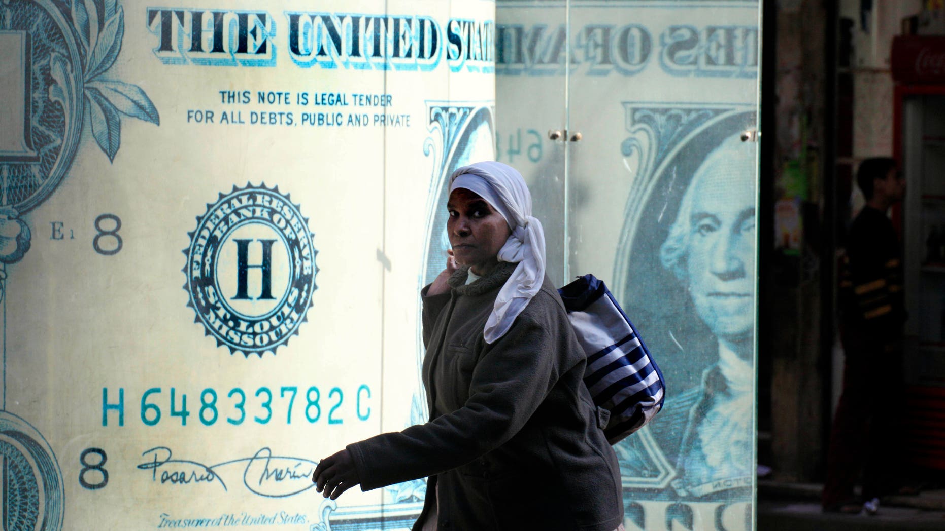 Jan. 31: An Egyptian walks in front of a closed currency exchange office in Cairo, Egypt. The Egyptian stock exchange says trading will resume Feb. 13.